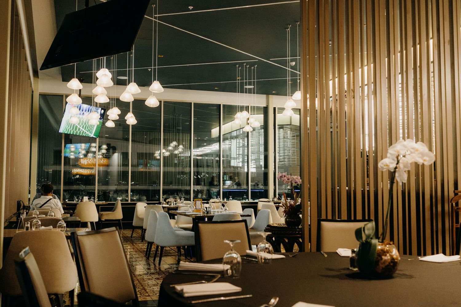 Modern office interior with glass walls, metal beams, and sleek furniture showcases contemporary workspace design.