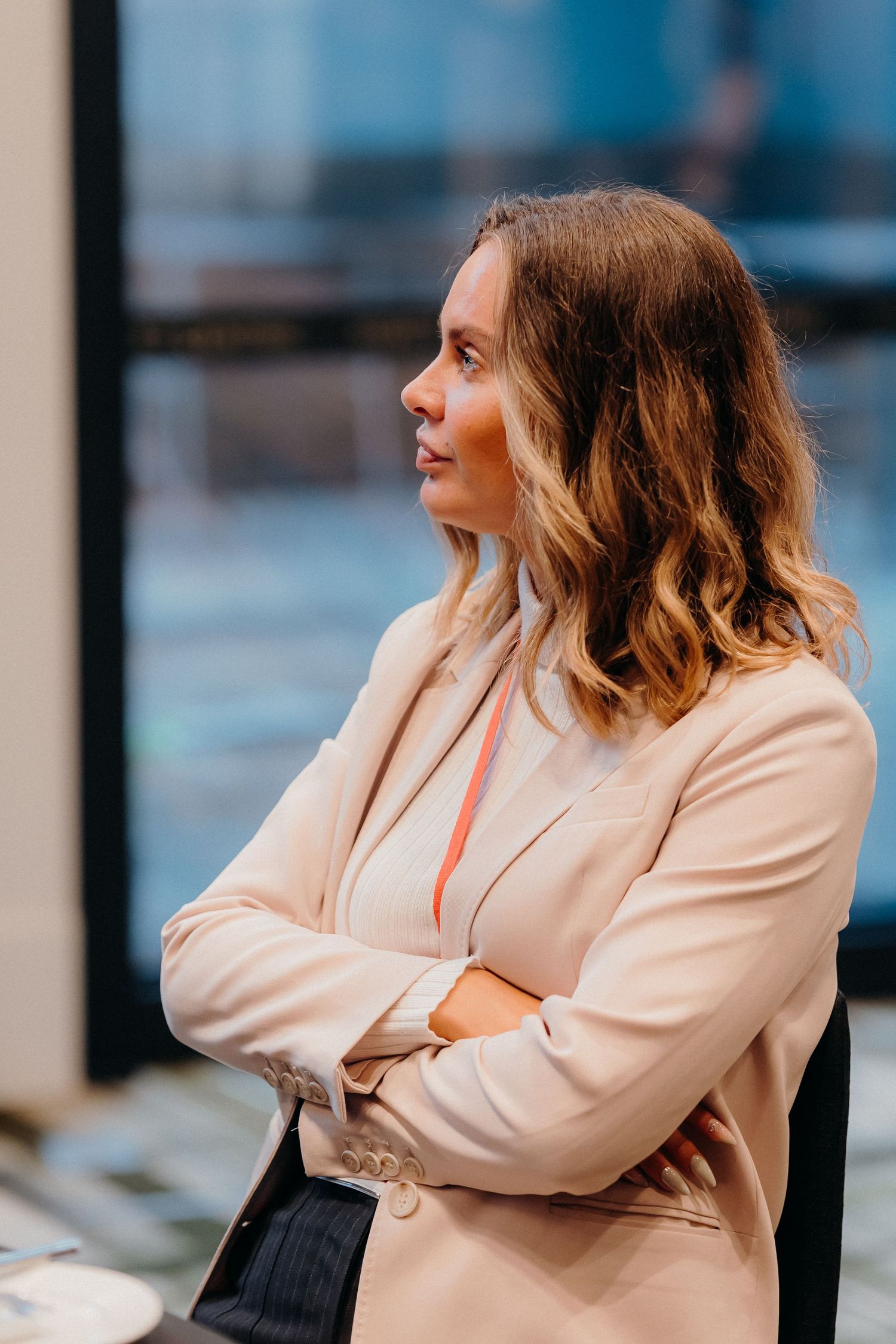 Woman in beige blazer poses thoughtfully against blurred urban background in multi-frame sequence.