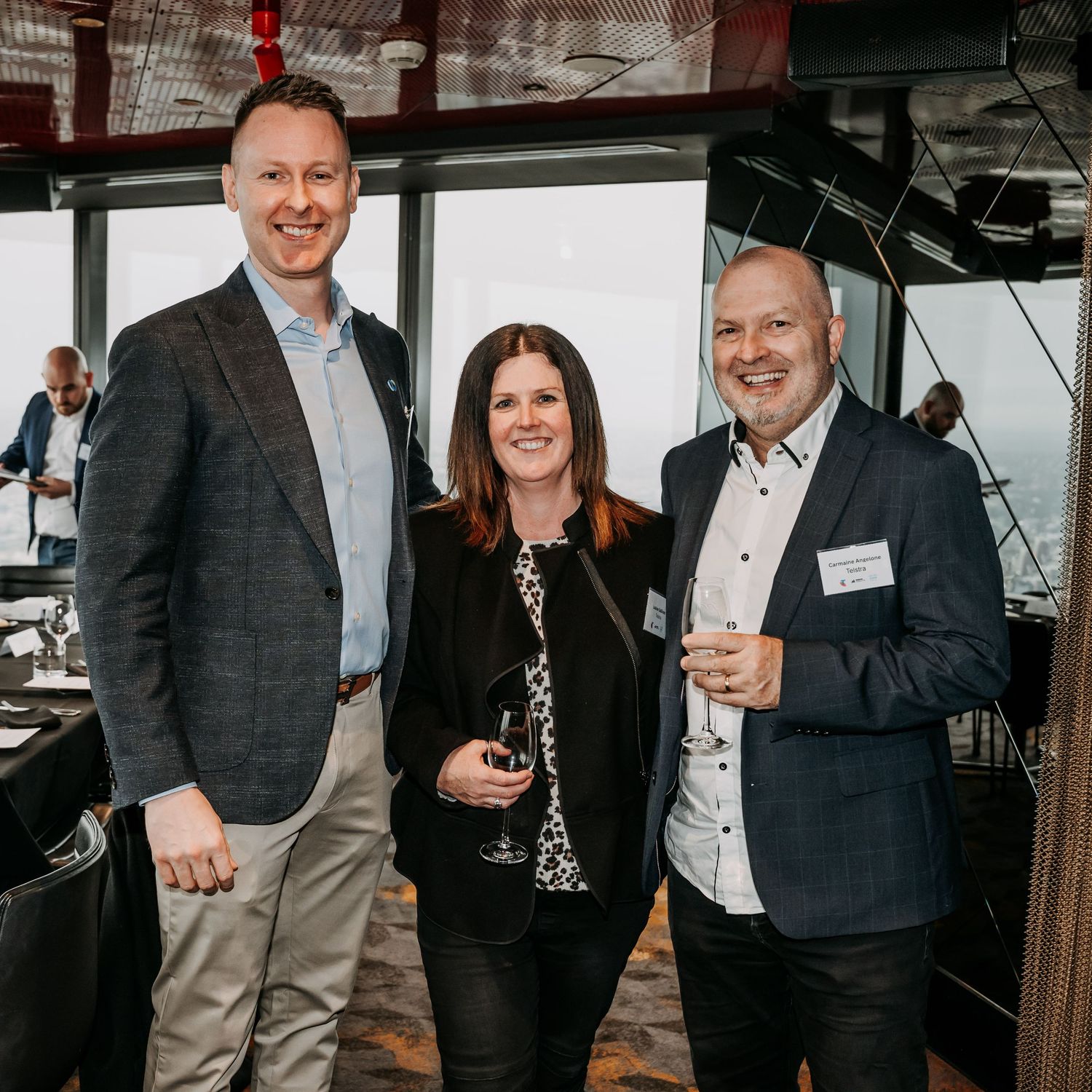 Group of professionals networking and socializing at a business event in a modern office space.