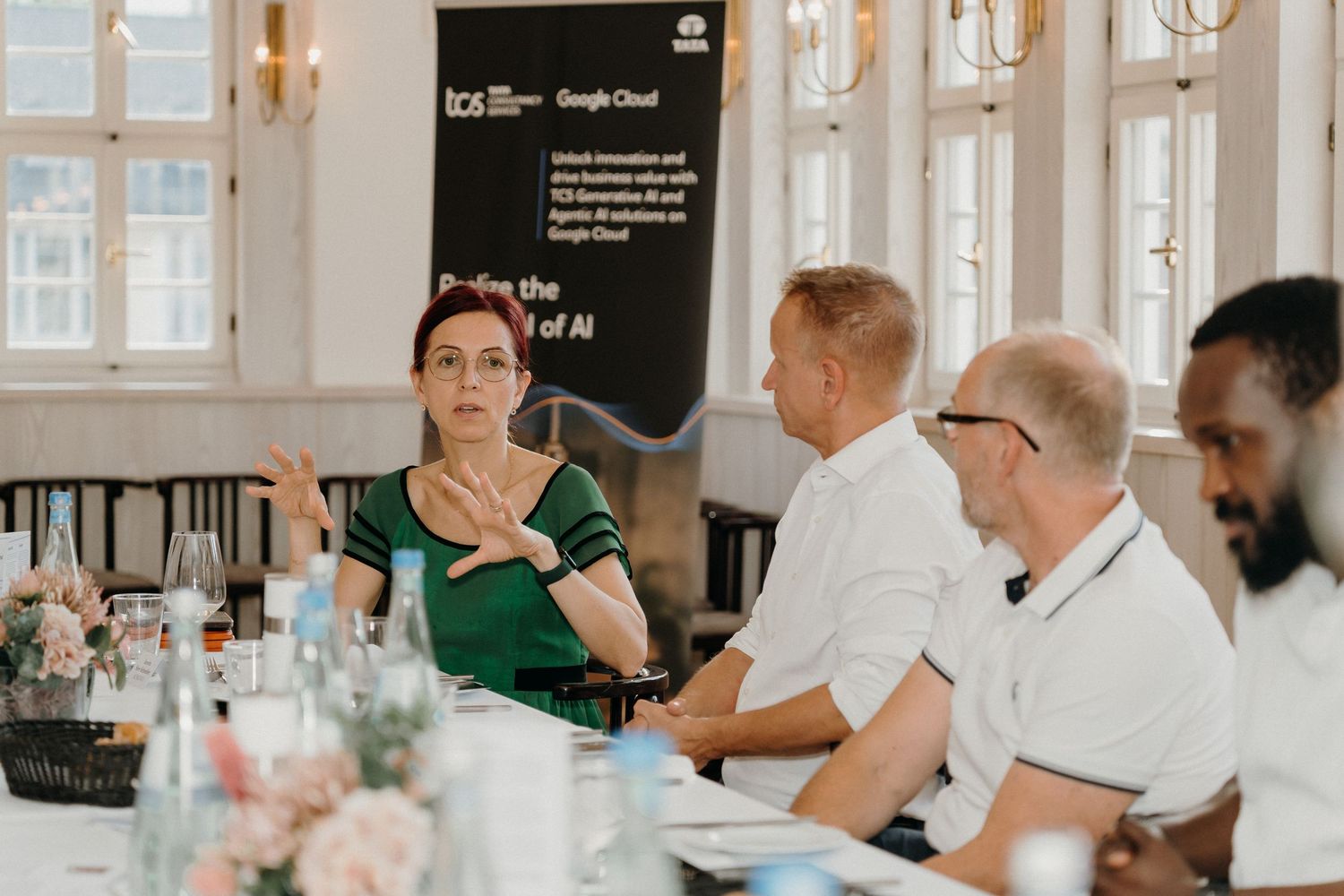 Business professionals at a TCS Google Cloud AI innovation roundtable discussion in an elegant conference room.