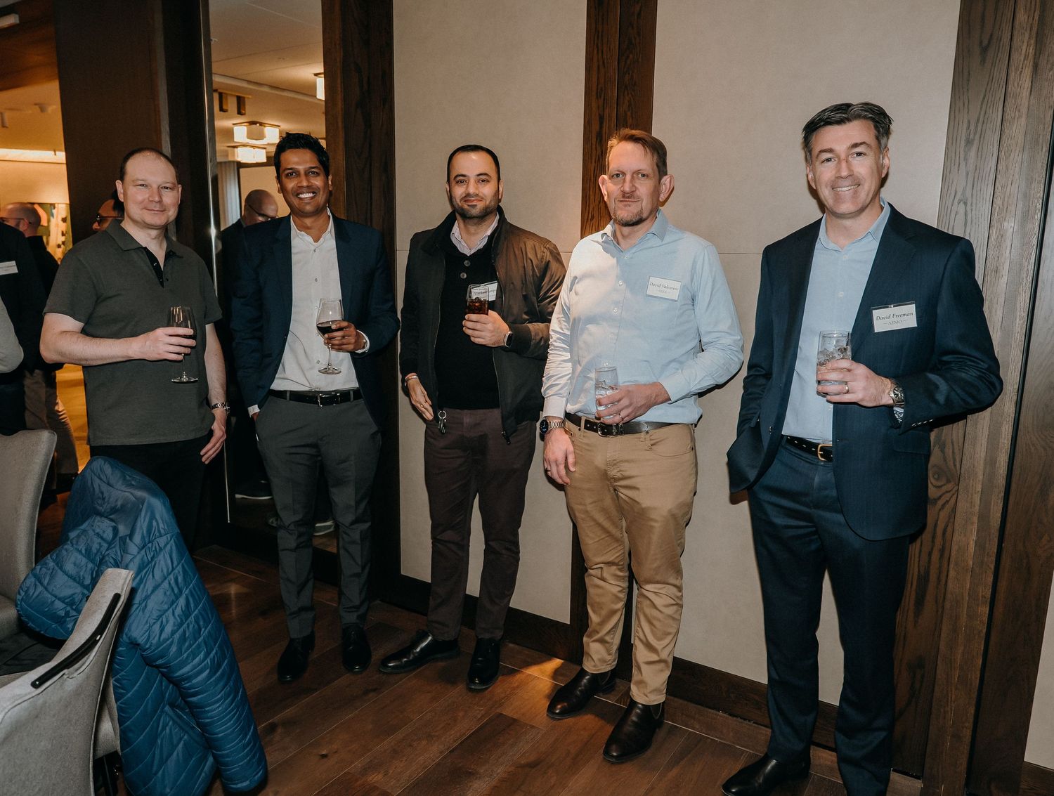 A group of business professionals gathered in a hallway at a networking event.