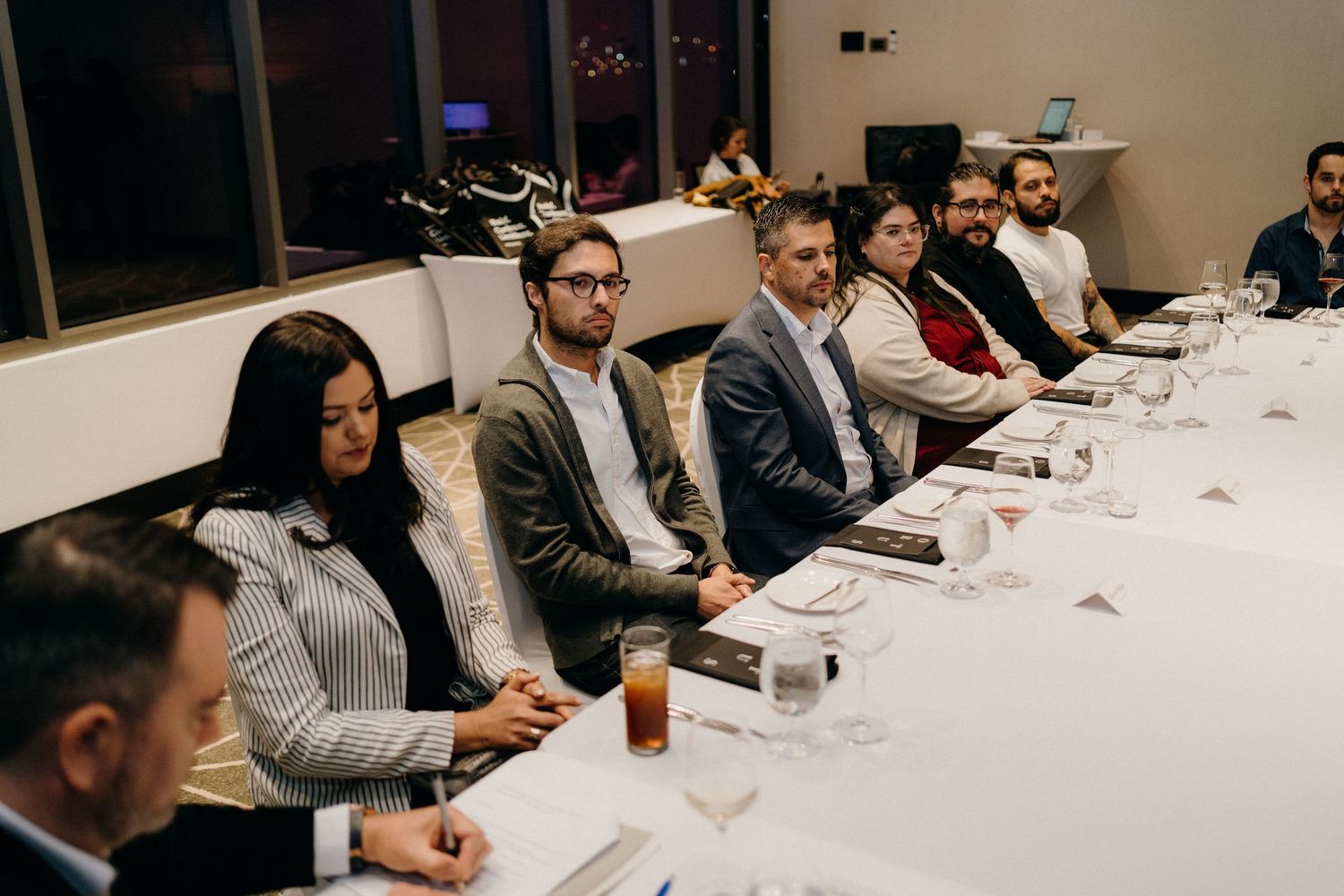 Business professionals sitting at a long conference table during a corporate meeting.