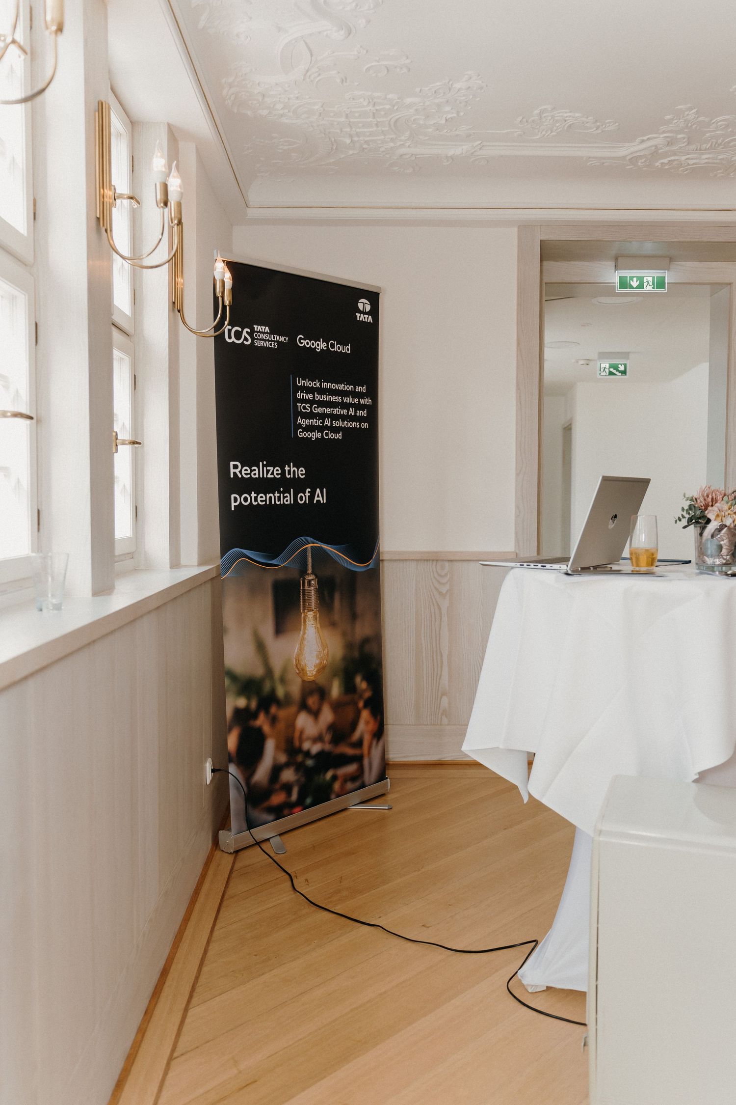 TCS and Google Cloud AI banner reading 'Realize the potential of AI' displayed at a corporate event venue.
