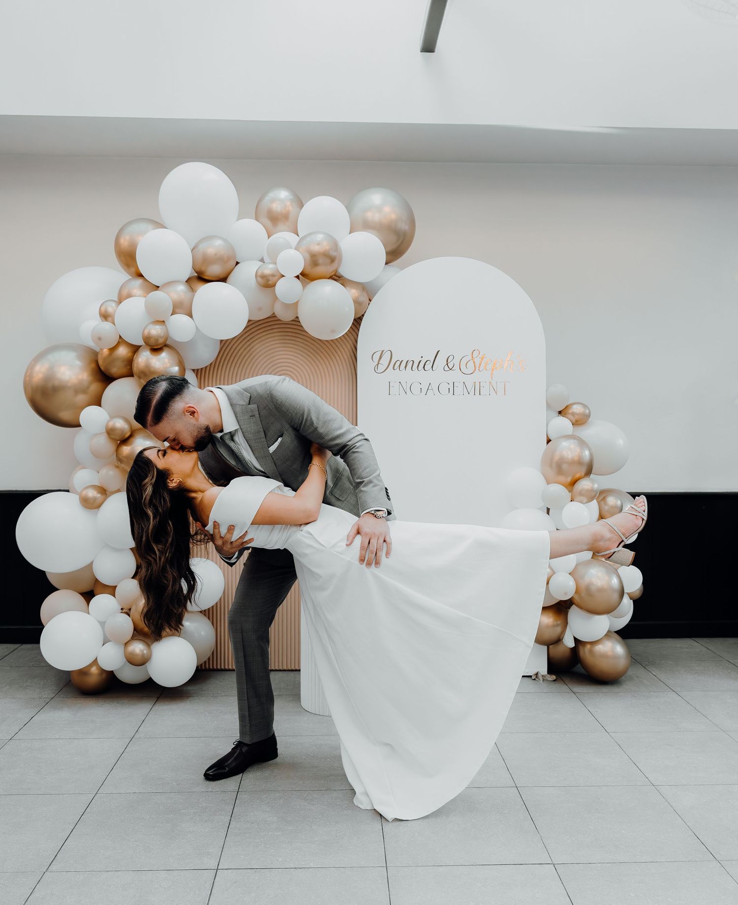A romantic photo sequence shows newlyweds posing with elegant white and gold balloon arches at their wedding celebration.