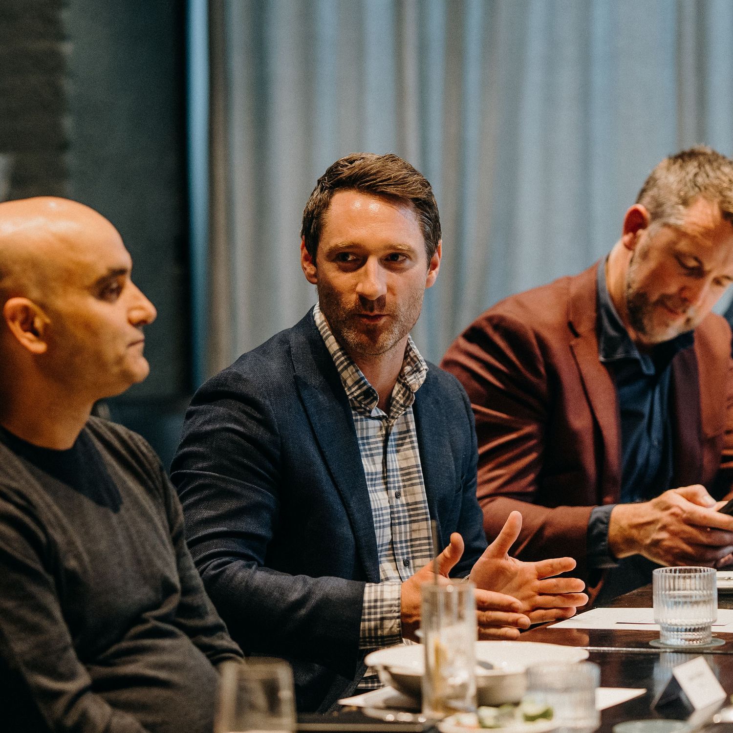 People engaged in an animated business discussion at a conference table during a meeting.