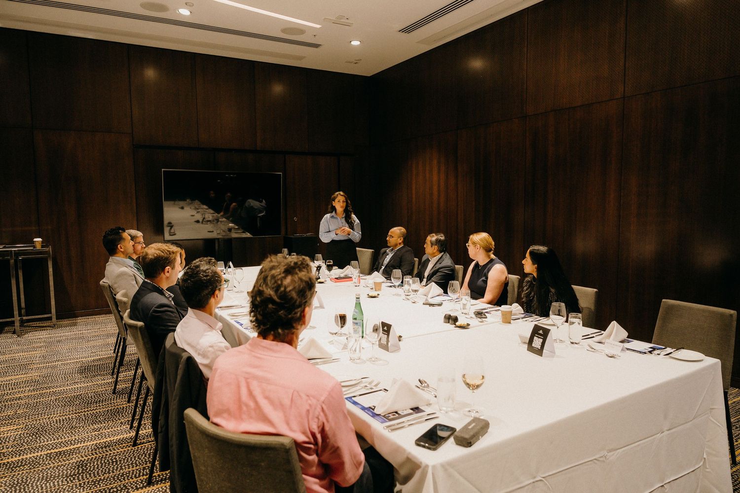 Business professionals seated around a conference table during a formal meeting in an elegant boardroom.