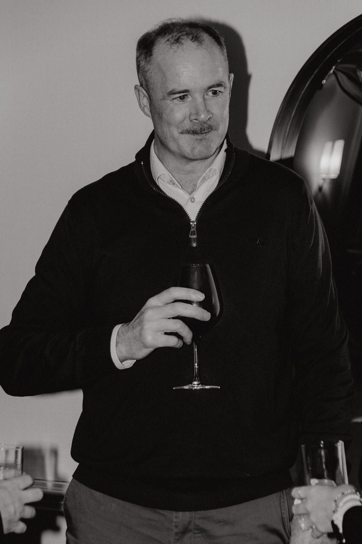 Four black and white photos show someone in a dark sweater sitting and drinking from a glass.