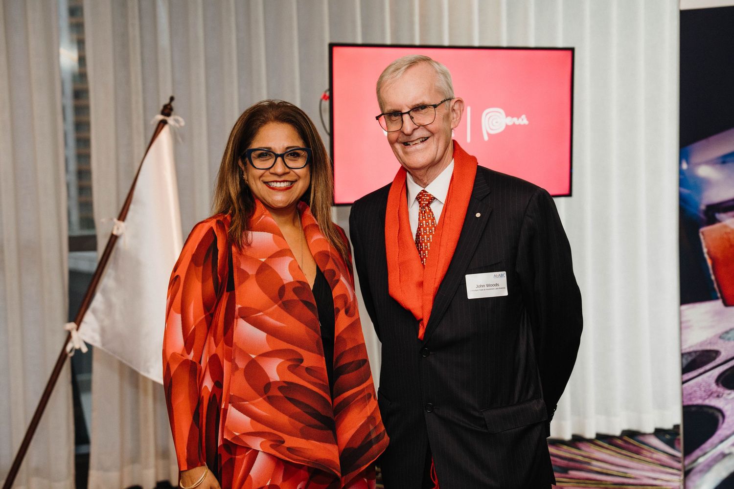 A group of people wearing red and black formal attire pose together at a professional event.