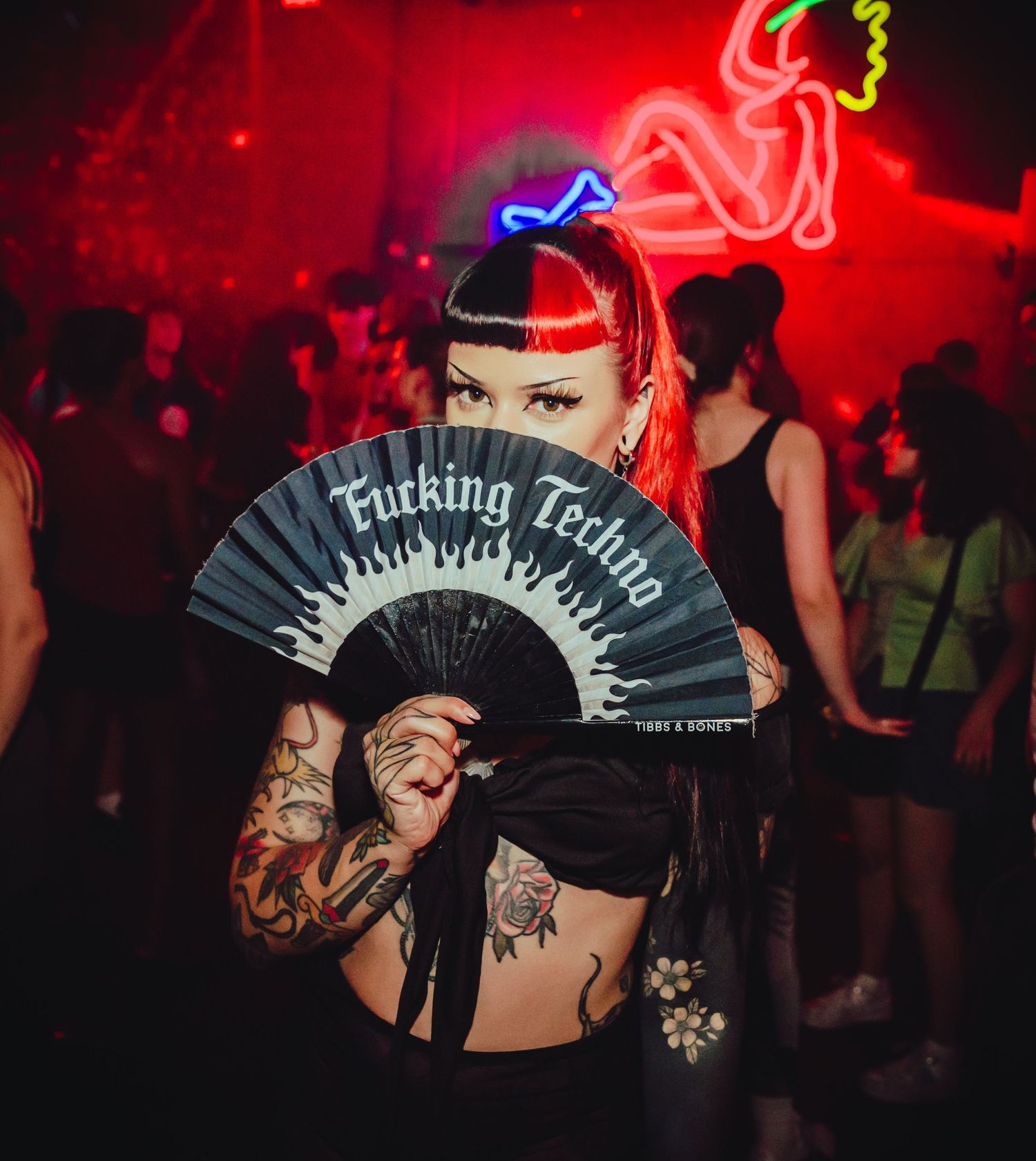 Dancers enjoying an energetic nightclub party scene with vivid red lighting and neon accents.