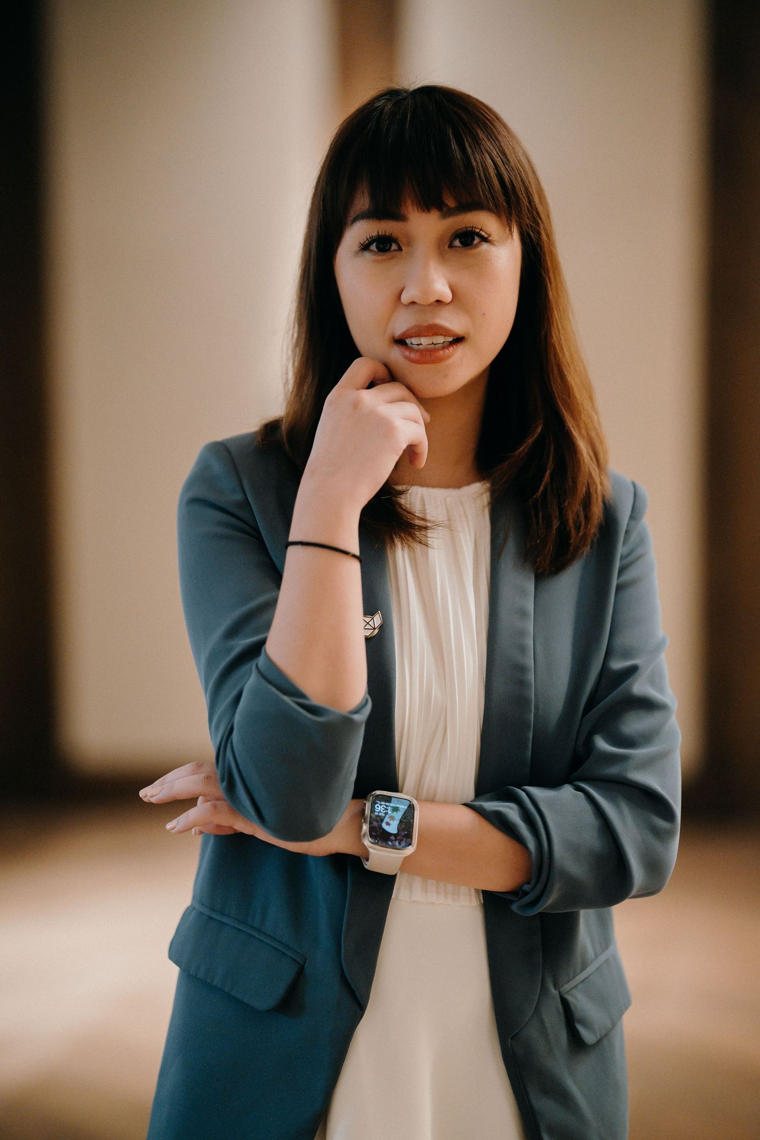 Professional wearing a gray blazer and white top poses in various thoughtful positions against a neutral background.