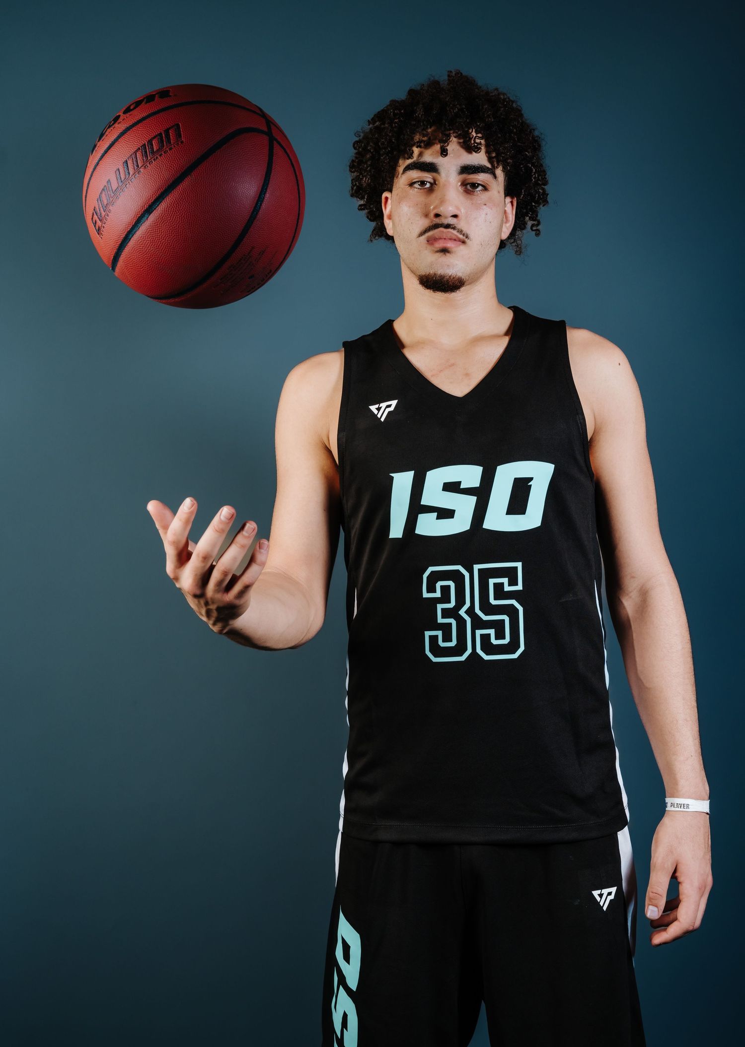 Basketball player in black ISU jersey number 35 poses with ball against dark background for sports portrait.