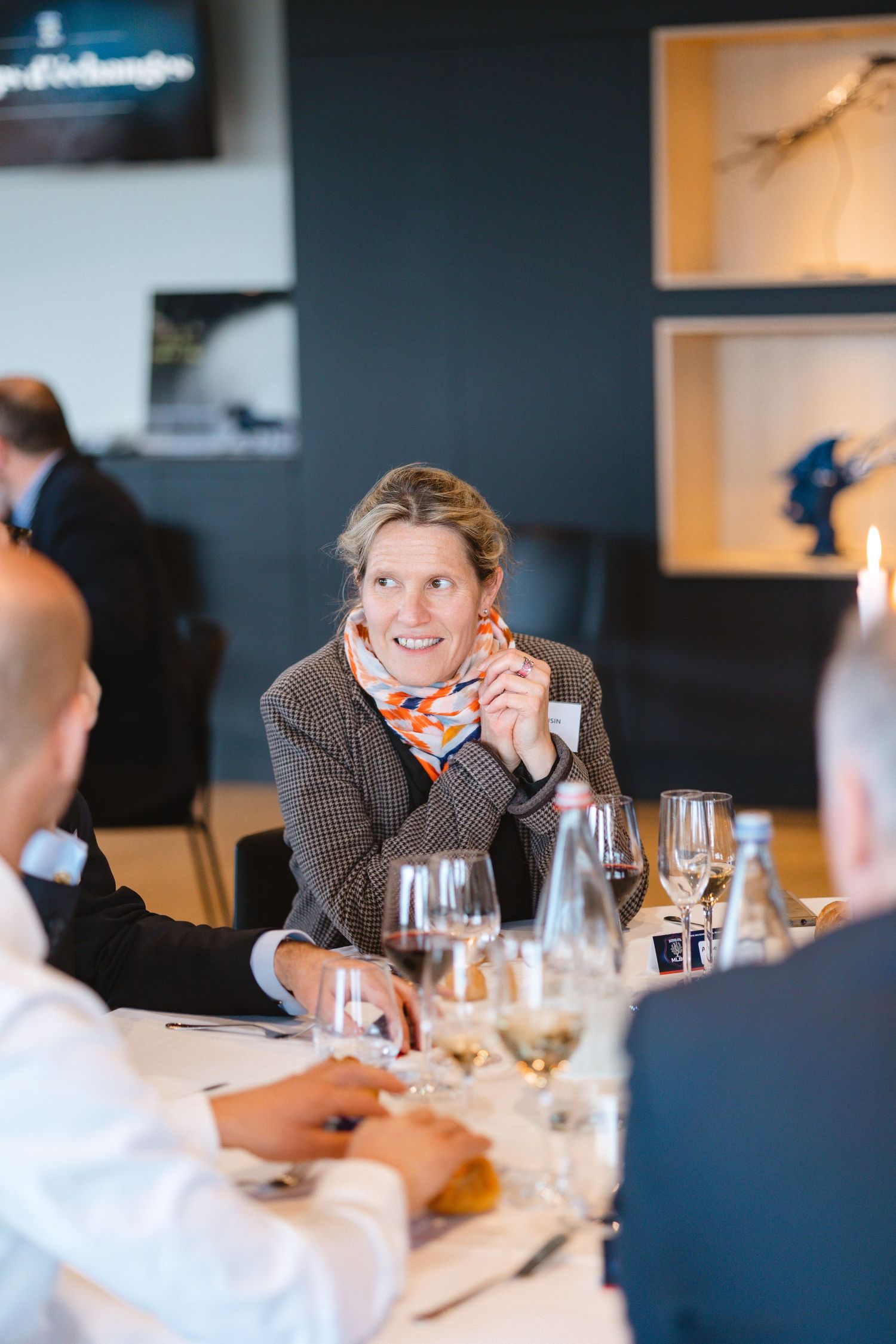 Attendees enjoying conversation and wine at an upscale business dinner event.