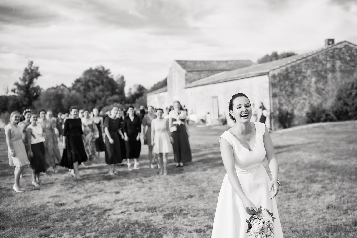 Black and white photo collage showing people gathered outdoors on a grassy hillside during a social event.