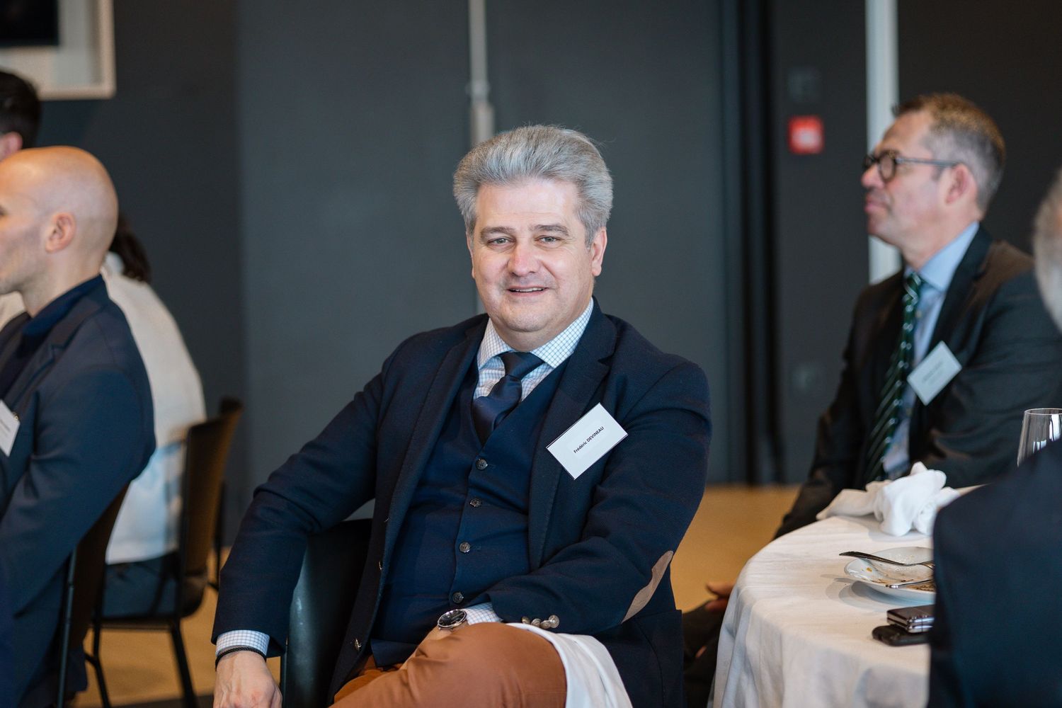 Business conference attendee seated in formal attire.