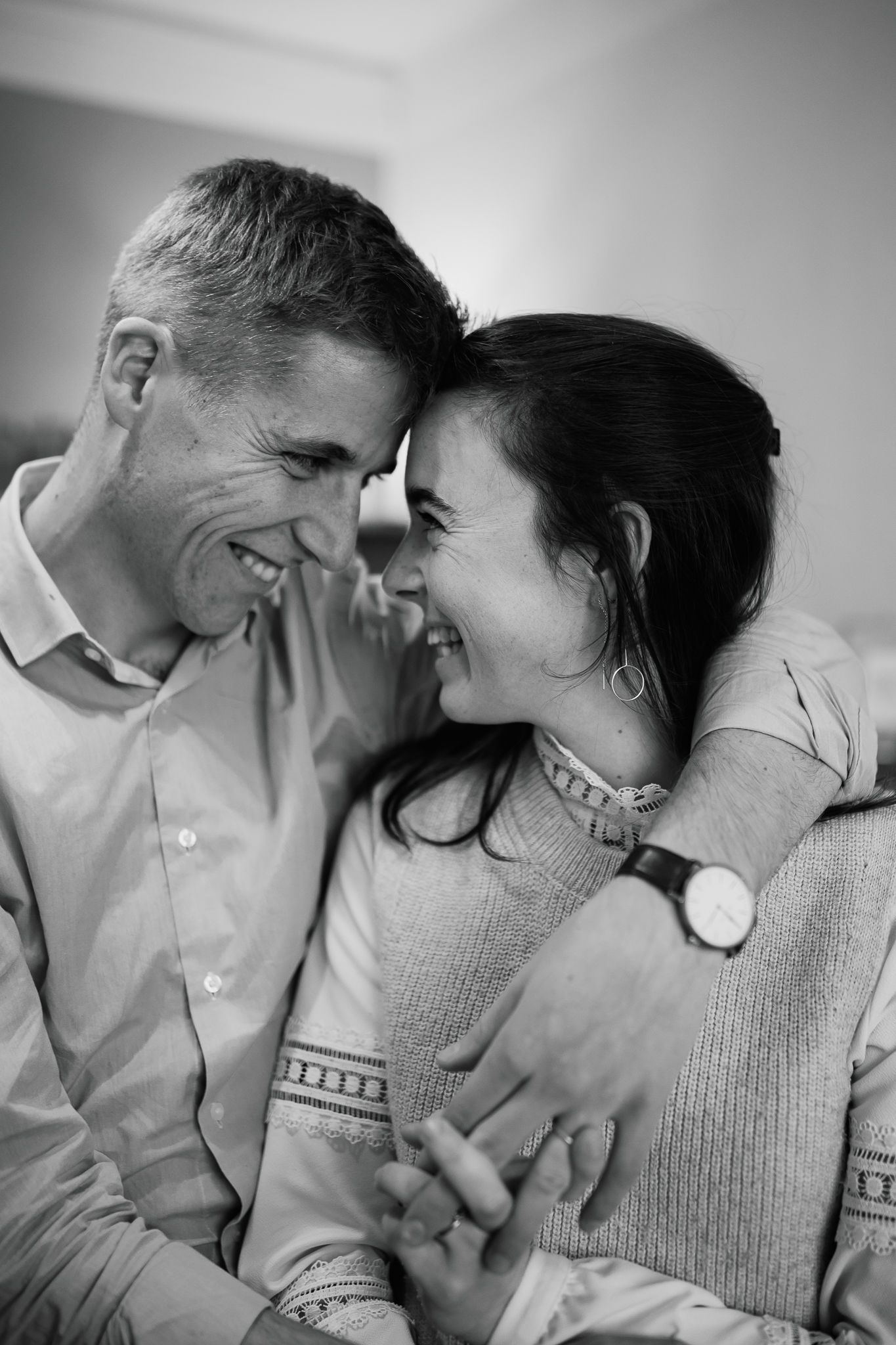 Photographie des parents qui se regardent, amoureux et complices pendant que leurs enfants jouent.