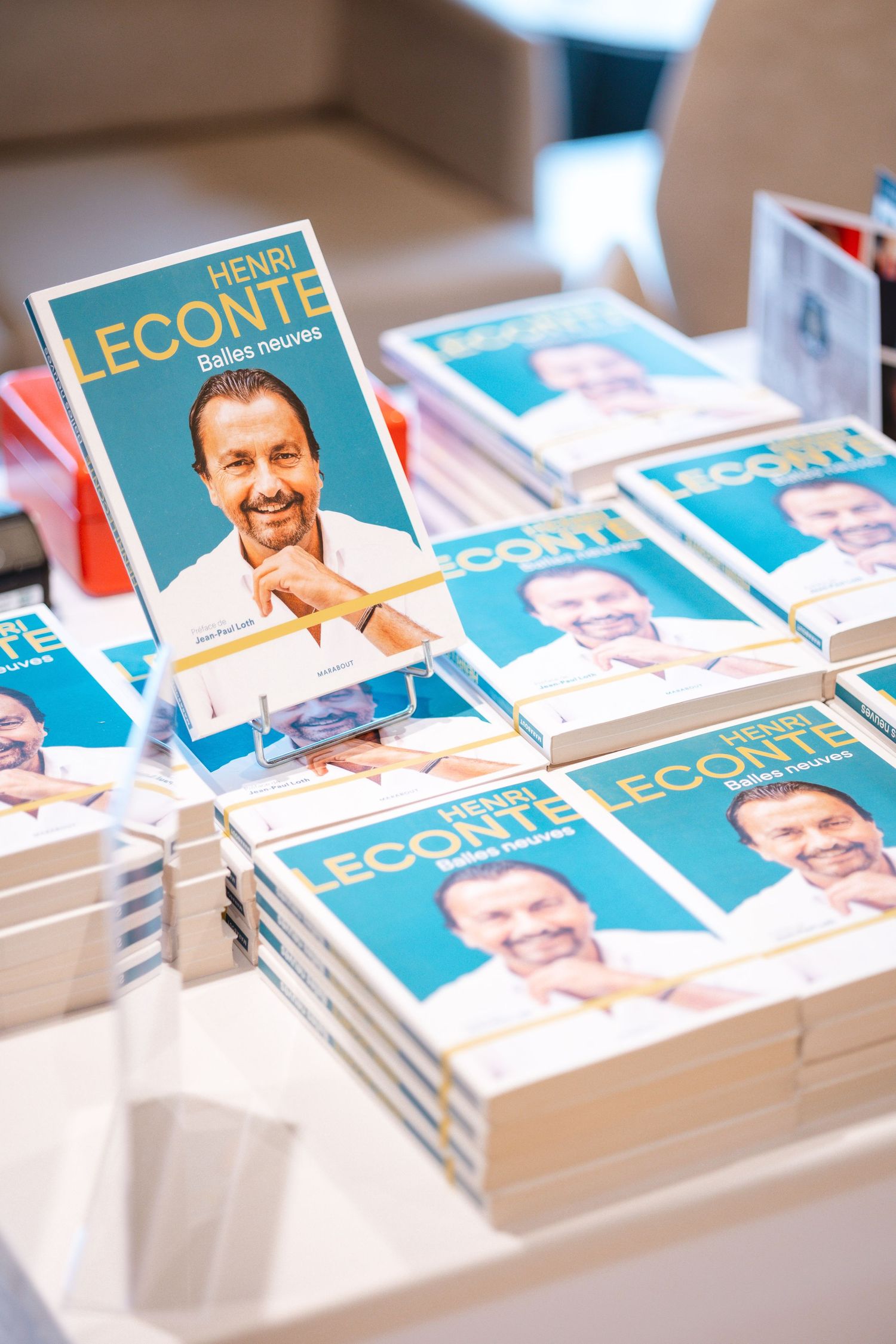 Stack of business books displayed on white table at professional event.