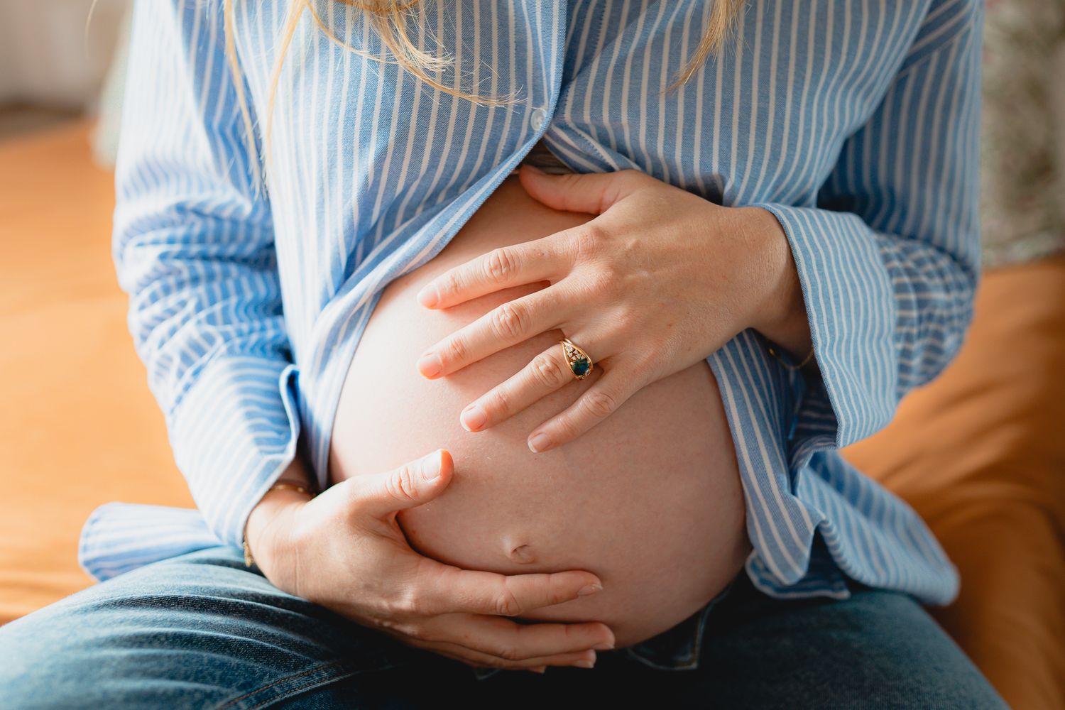 Photo de grossesse ou maternité, de la maman qui montre son ventre rond car elle attend un enfant, depuis sa chambre.