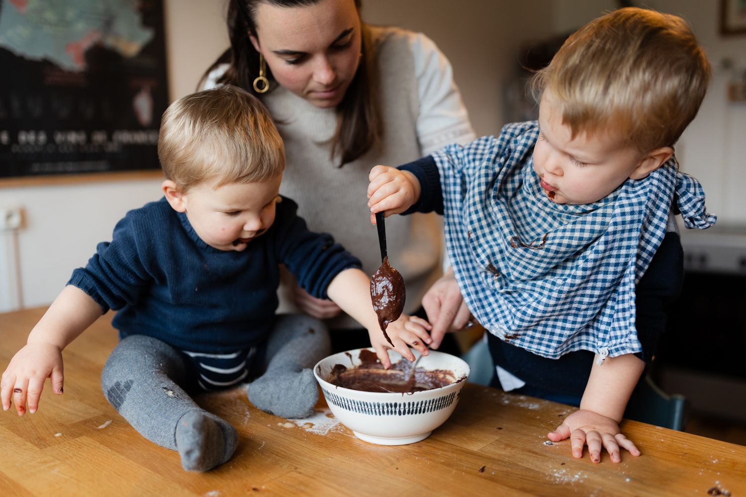 Photo de famille en train de cuisiner ensemble, activité entre maman et ses enfants pour des photos naturelles et souriantes.