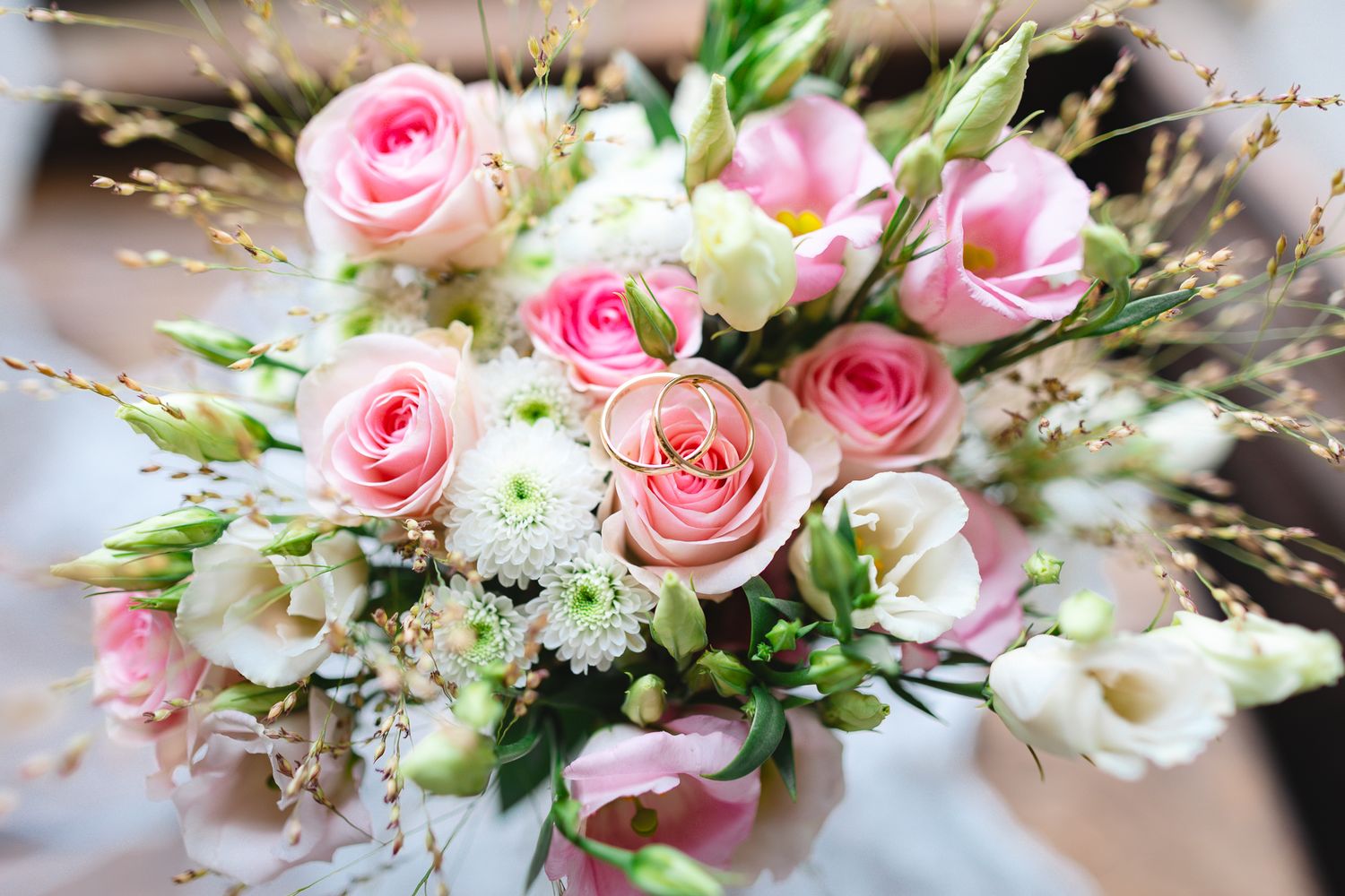 A beautiful bouquet of pink roses and white flowers arranged elegantly for a wedding or special occasion.