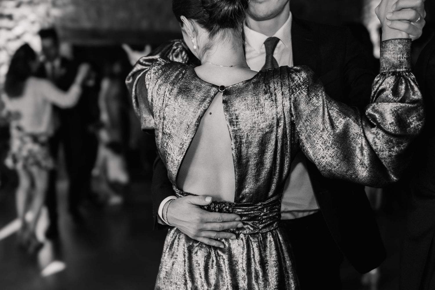 A person dancing in a glittery vintage-style dress at a party, captured in black and white photography.
