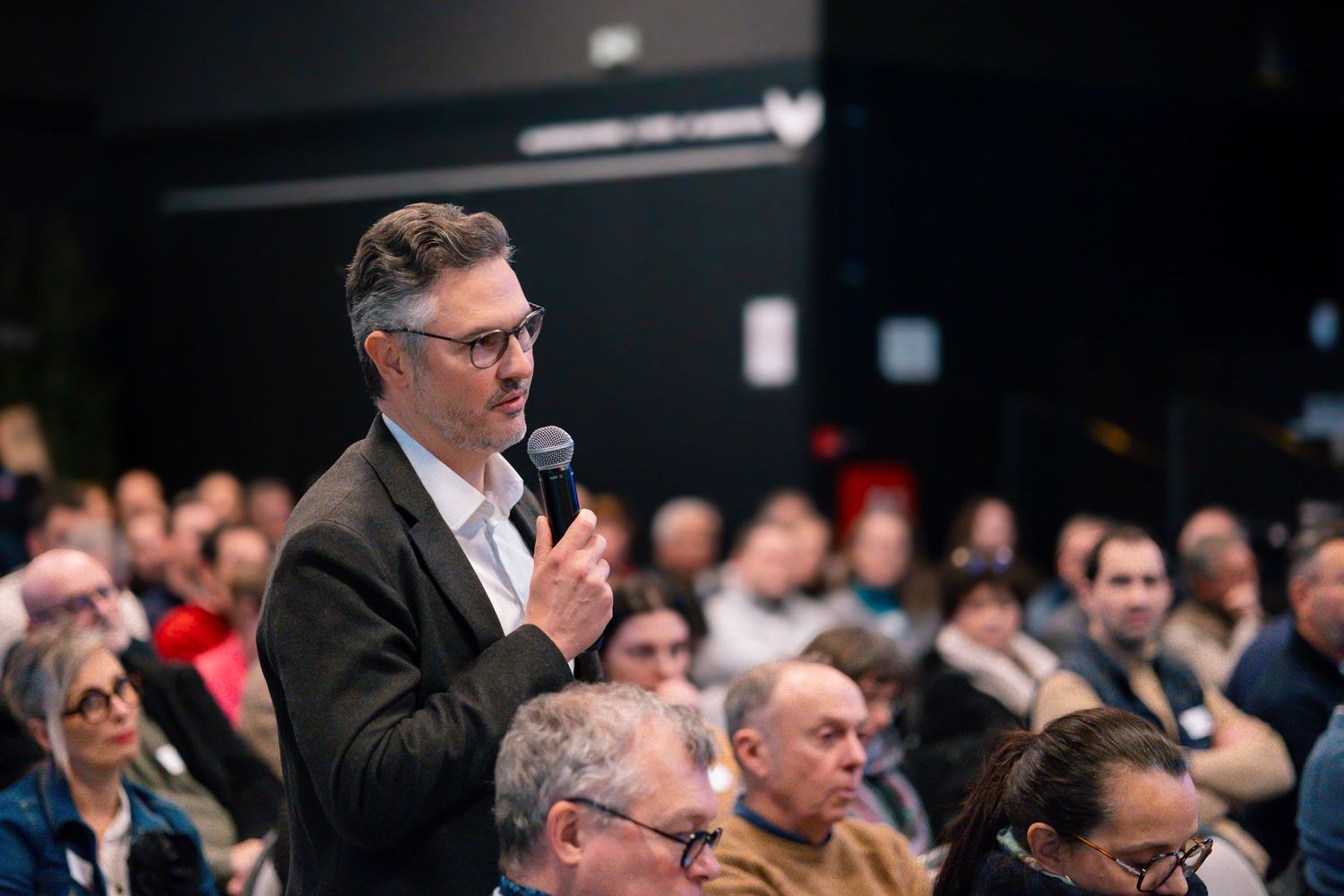Conference attendee asking question during Q&A session.