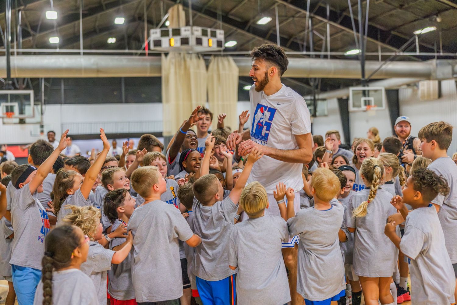 Chet Holmgren celebrates with youth campers at his ProCamp after winning a competition against a camper.