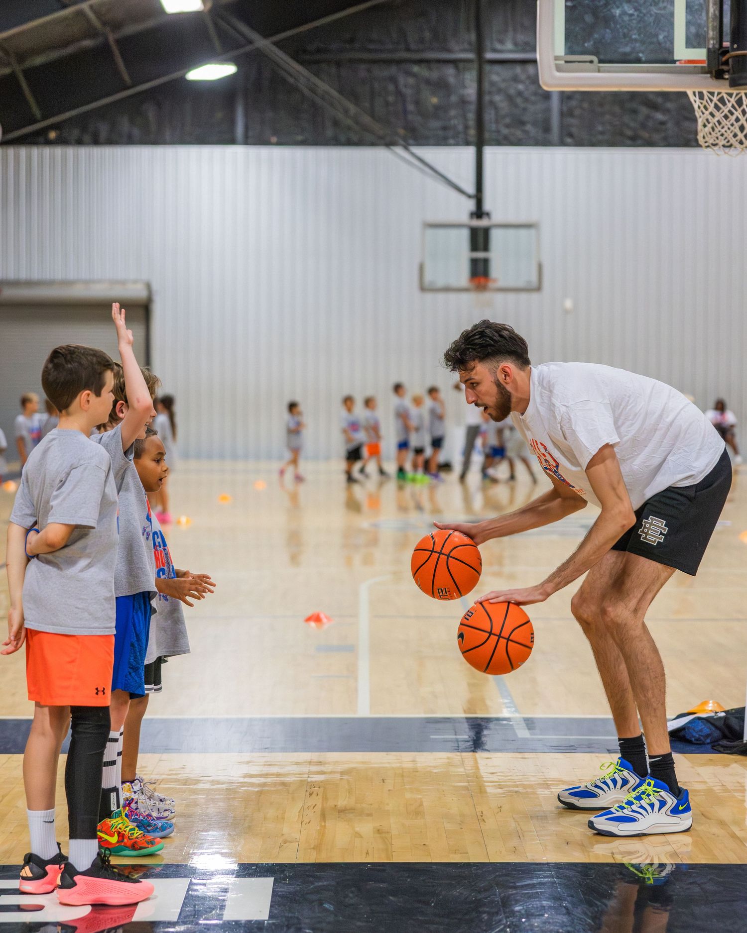 Chet Holmgren shows some campers how to dribble two balls at once.