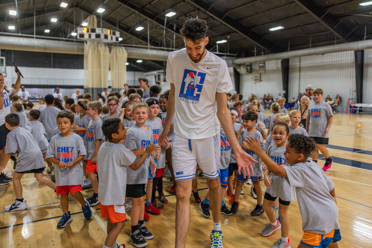 Chet Holmgren celebrates with youth campers after winning a competition against one of the campers.