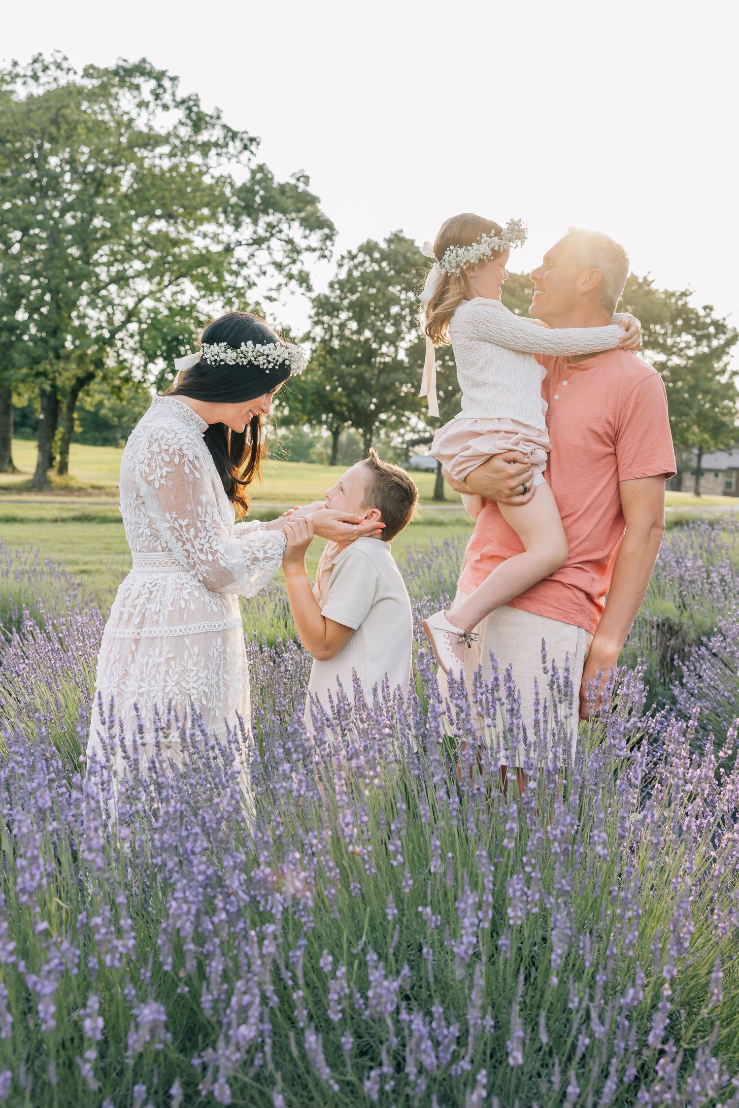A couple shares intimate moments in a blooming lavender field during a romantic photoshoot at sunset.