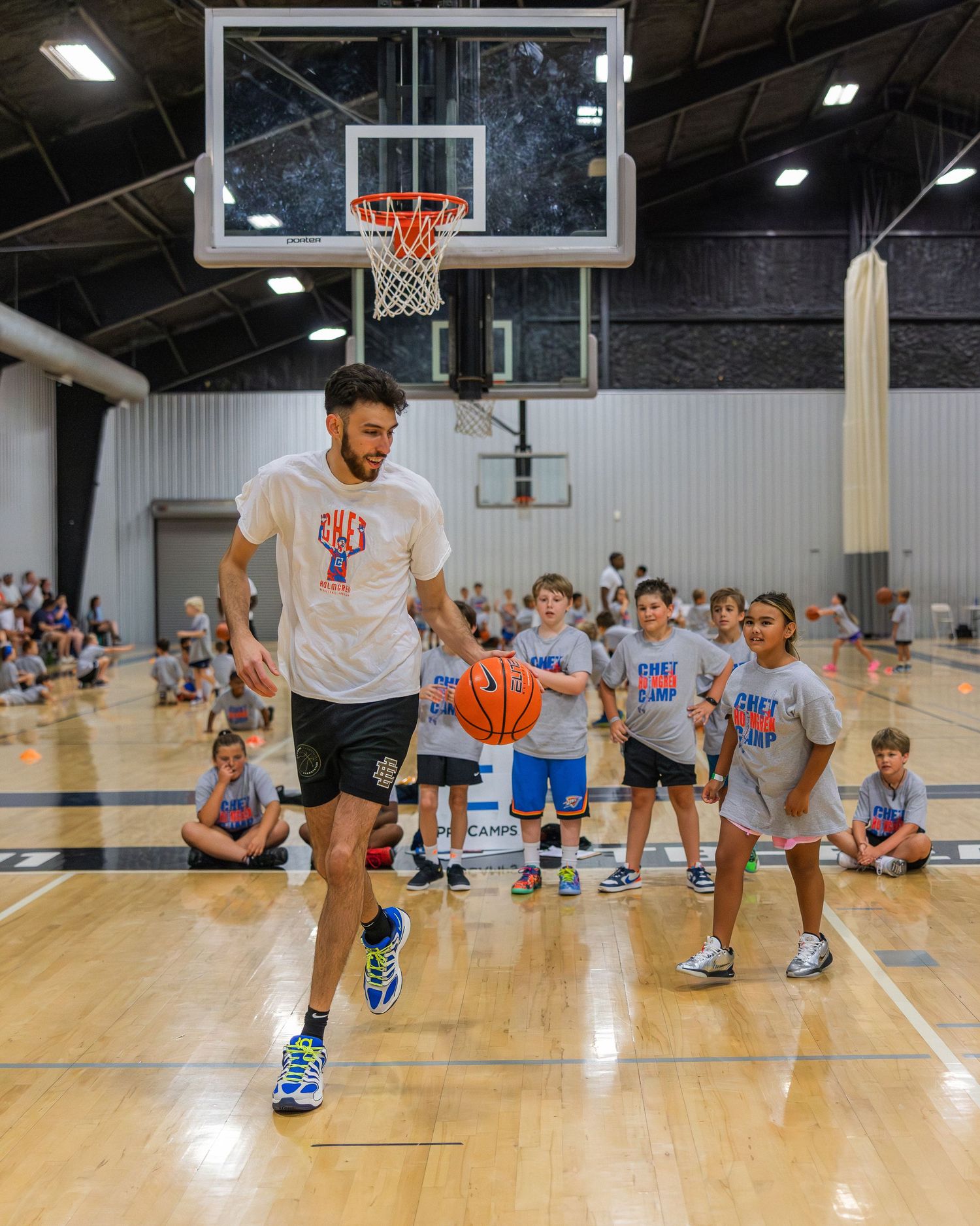 Campers watch Chet Holmgren challenge a youth camper to a one-on-one competition.