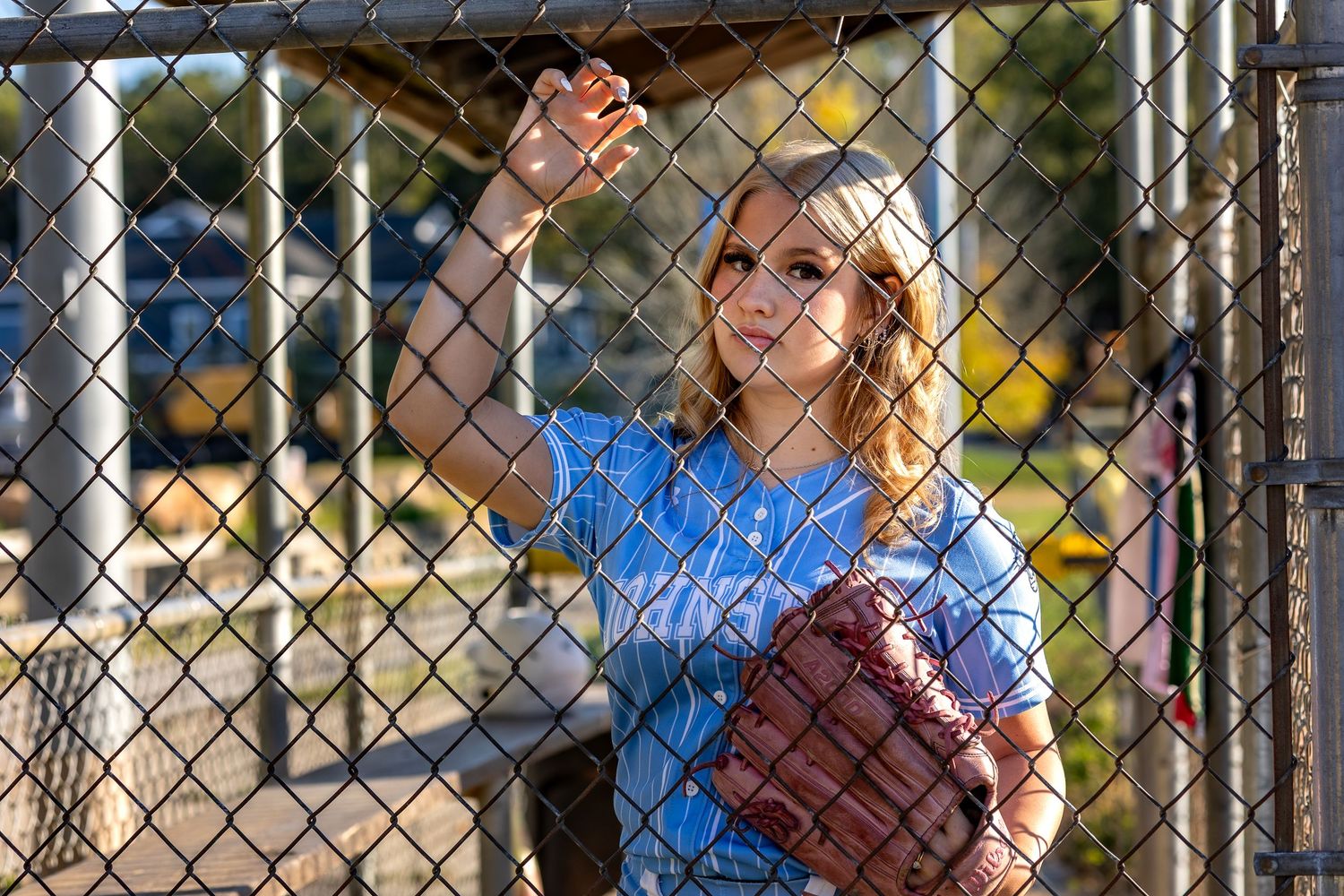 Students playing on a playground with a chain link fence during recess at an elementary school.