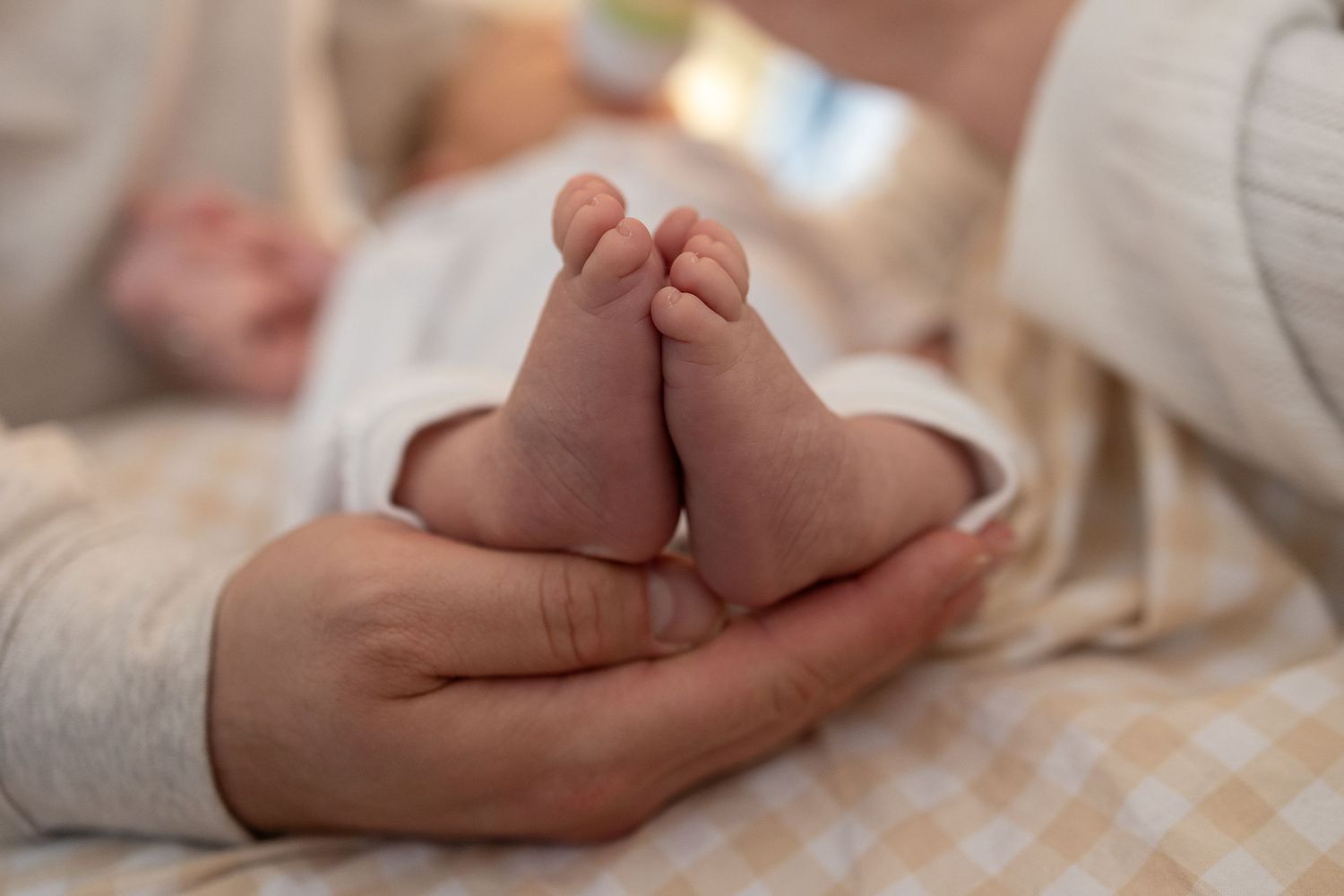 Detail shots focusing on gentle hand touches and tender moments with a newborn baby.