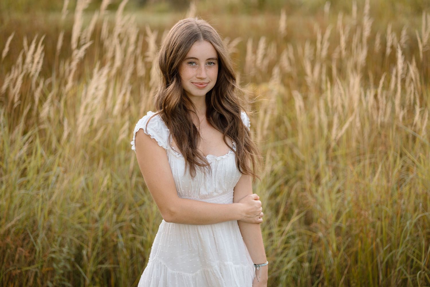 A serene portrait in a field of tall wheat grass during golden hour.