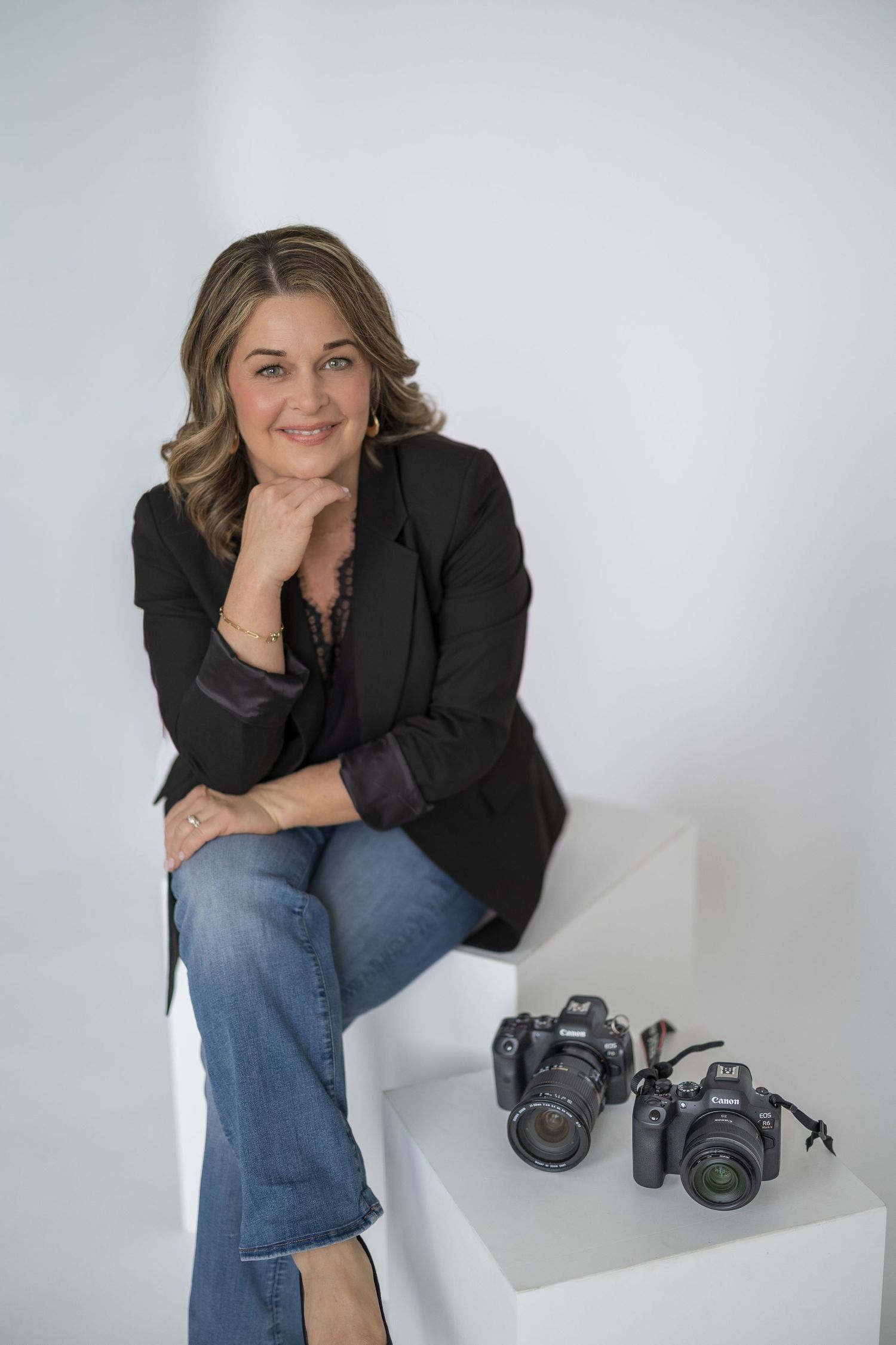 A series of professional headshots showing someone in a black blazer and jeans posing with camera equipment.