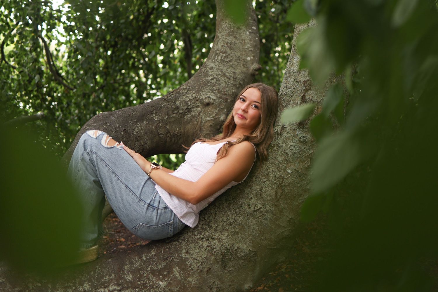 Natural garden portrait session with dappled sunlight filtering through tree leaves.
