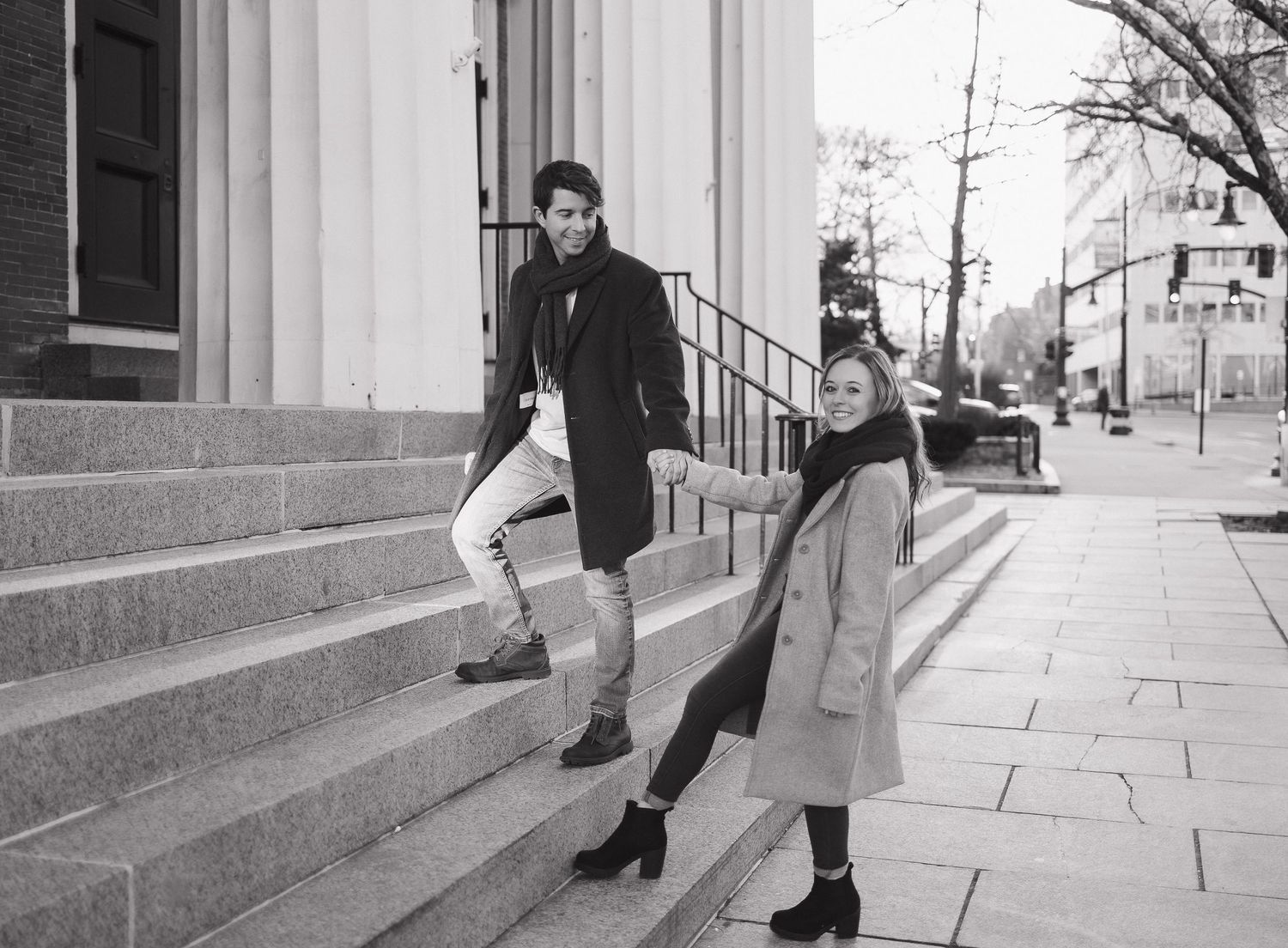 A playful moment captured on historic building steps in black and white.