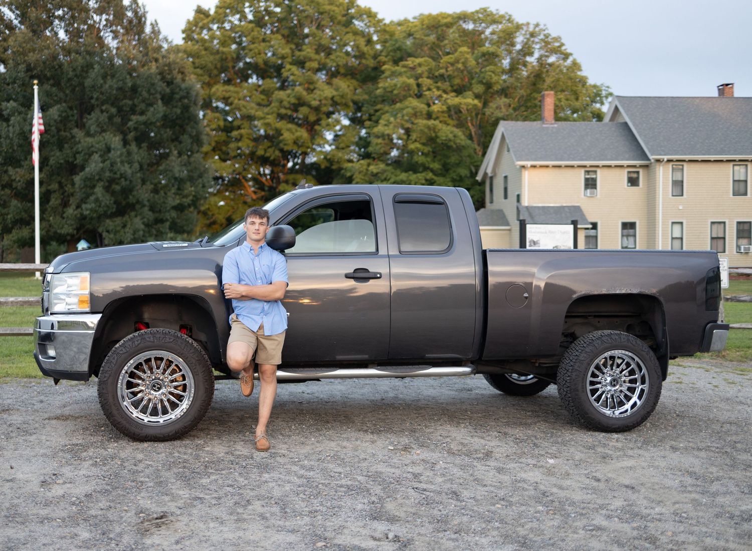 A lifted Chevrolet Silverado pickup truck parked in a gravel lot.