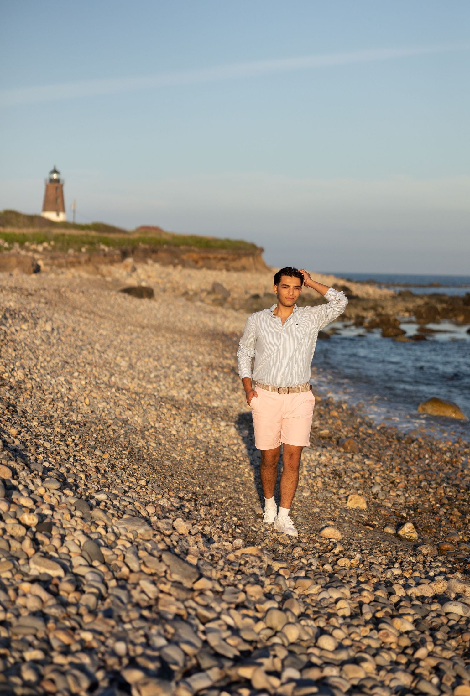 Rocky beach landscape at sunset with pebbles and ocean waves along a scenic coastline.
