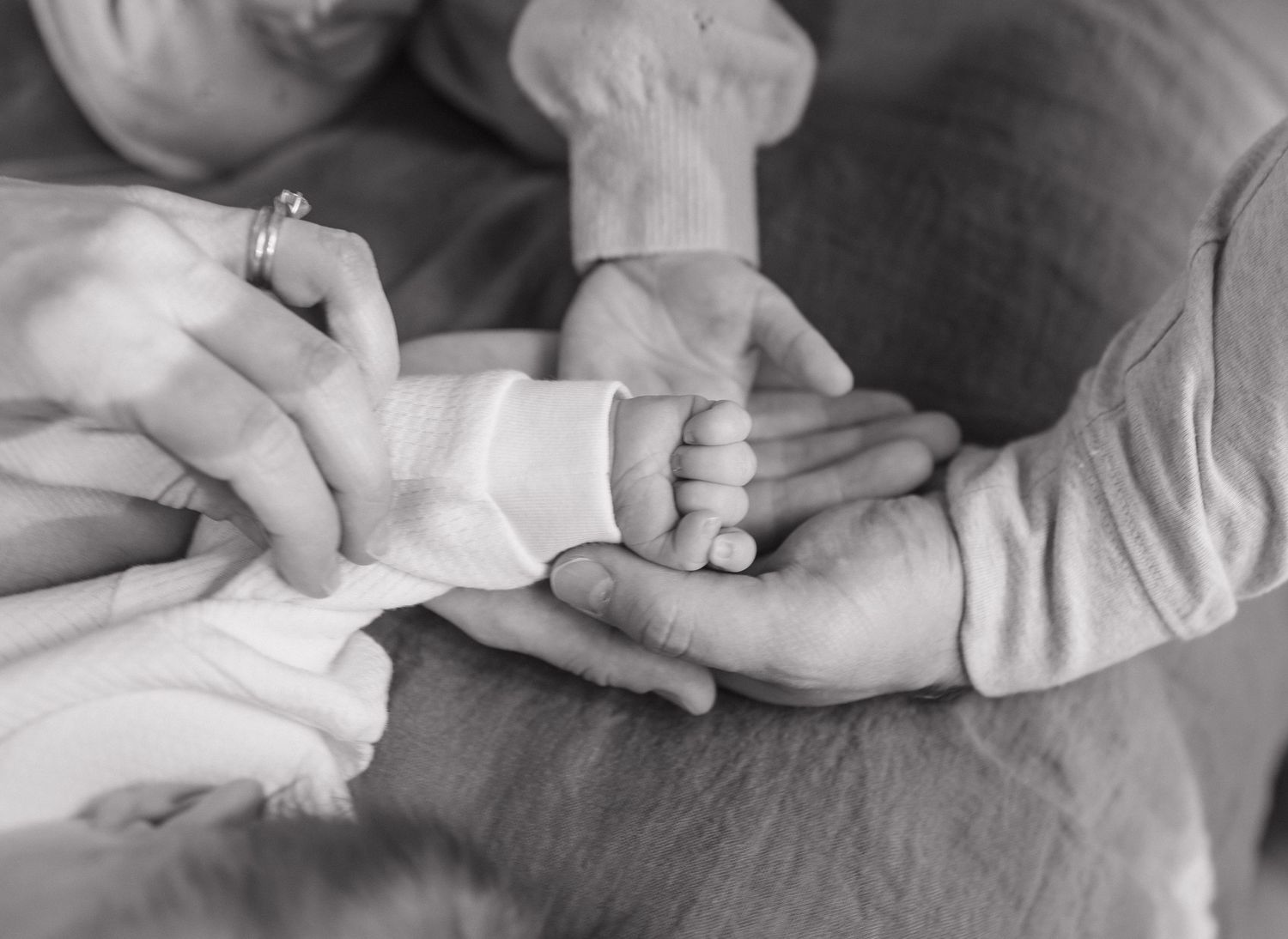A collection of black and white close-up photographs showing hands holding and touching in intimate gestures.