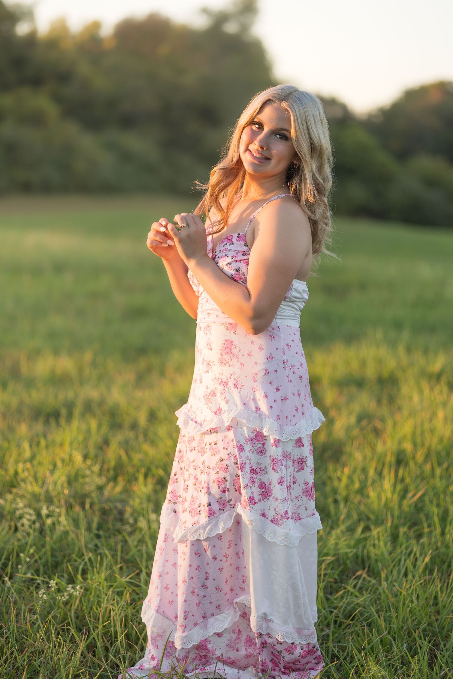 A figure in a floral sundress twirls joyfully in a sunlit meadow at golden hour.