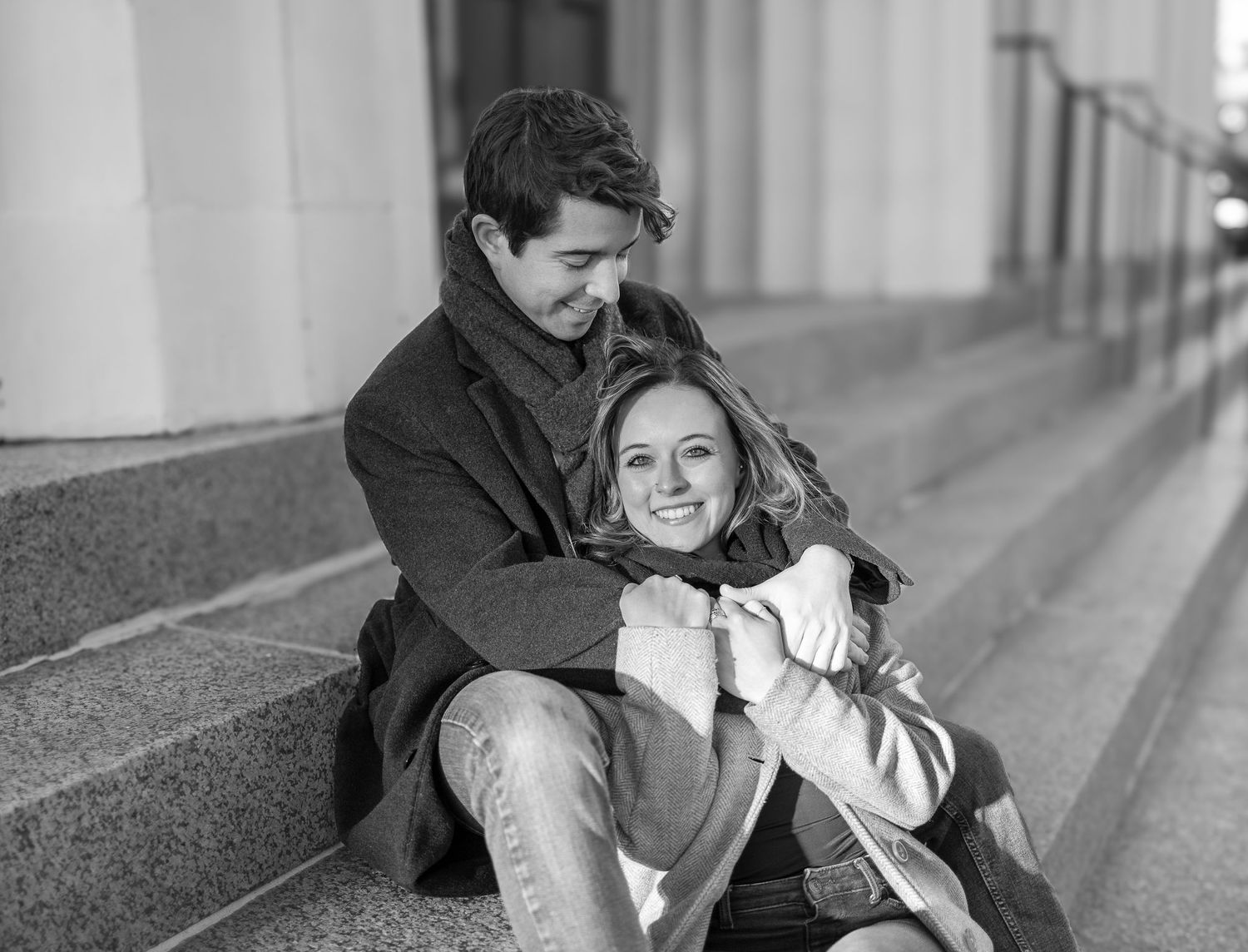 A black and white candid moment of joy captured on urban steps.