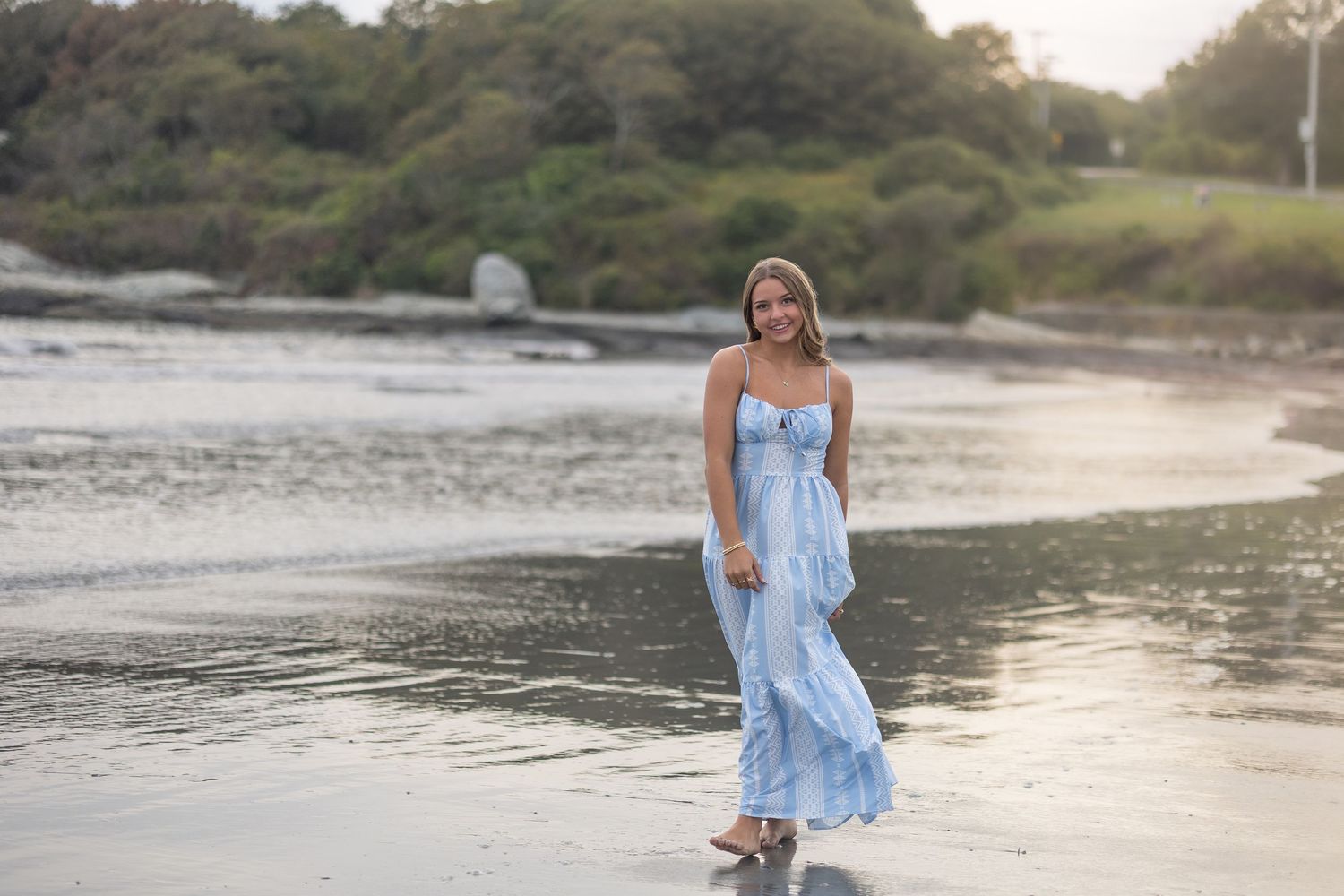 Beachside portrait session at sunset featuring light blue summer dress near the water.