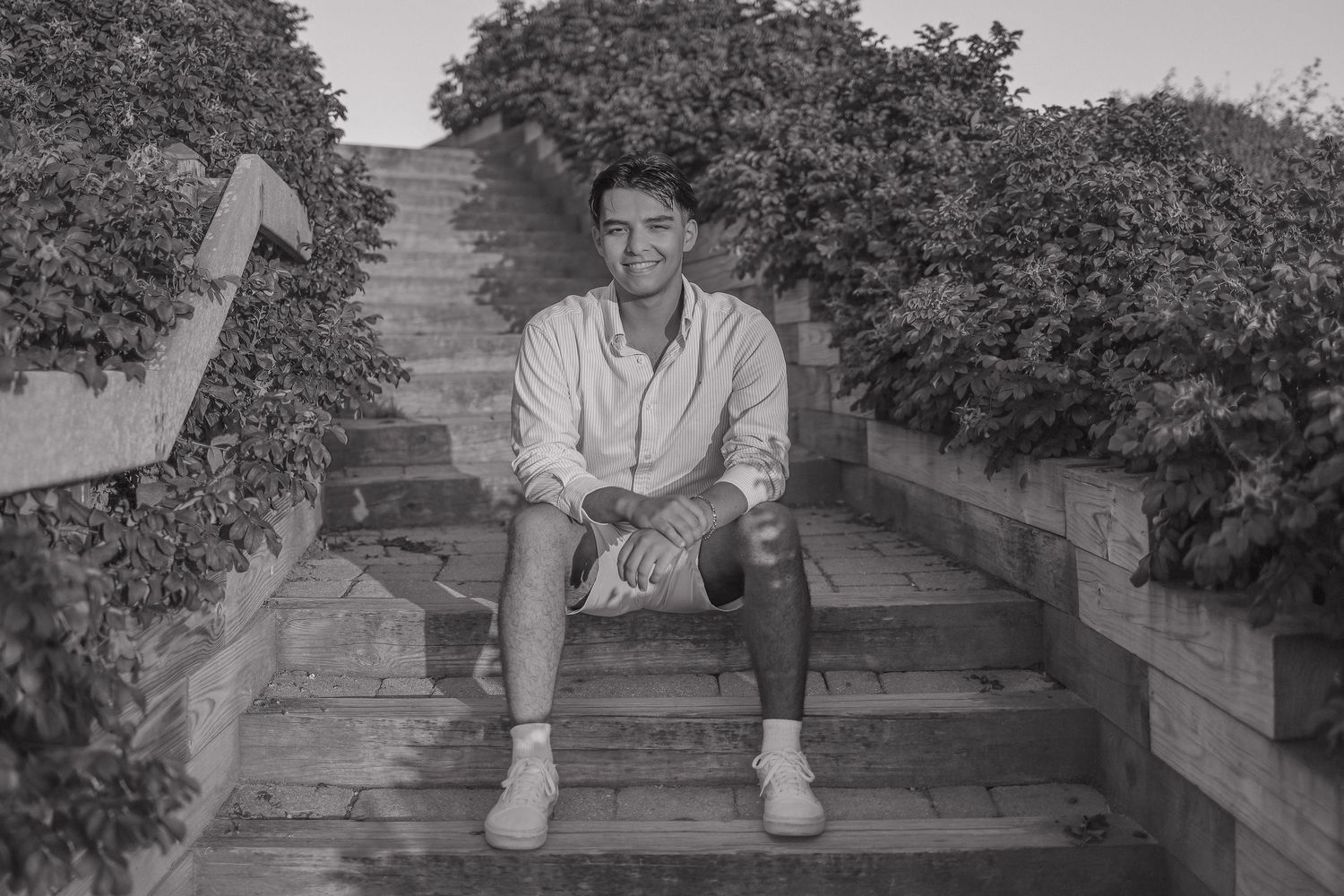 A series of black and white photographs showing someone sitting on wooden steps in a garden setting.