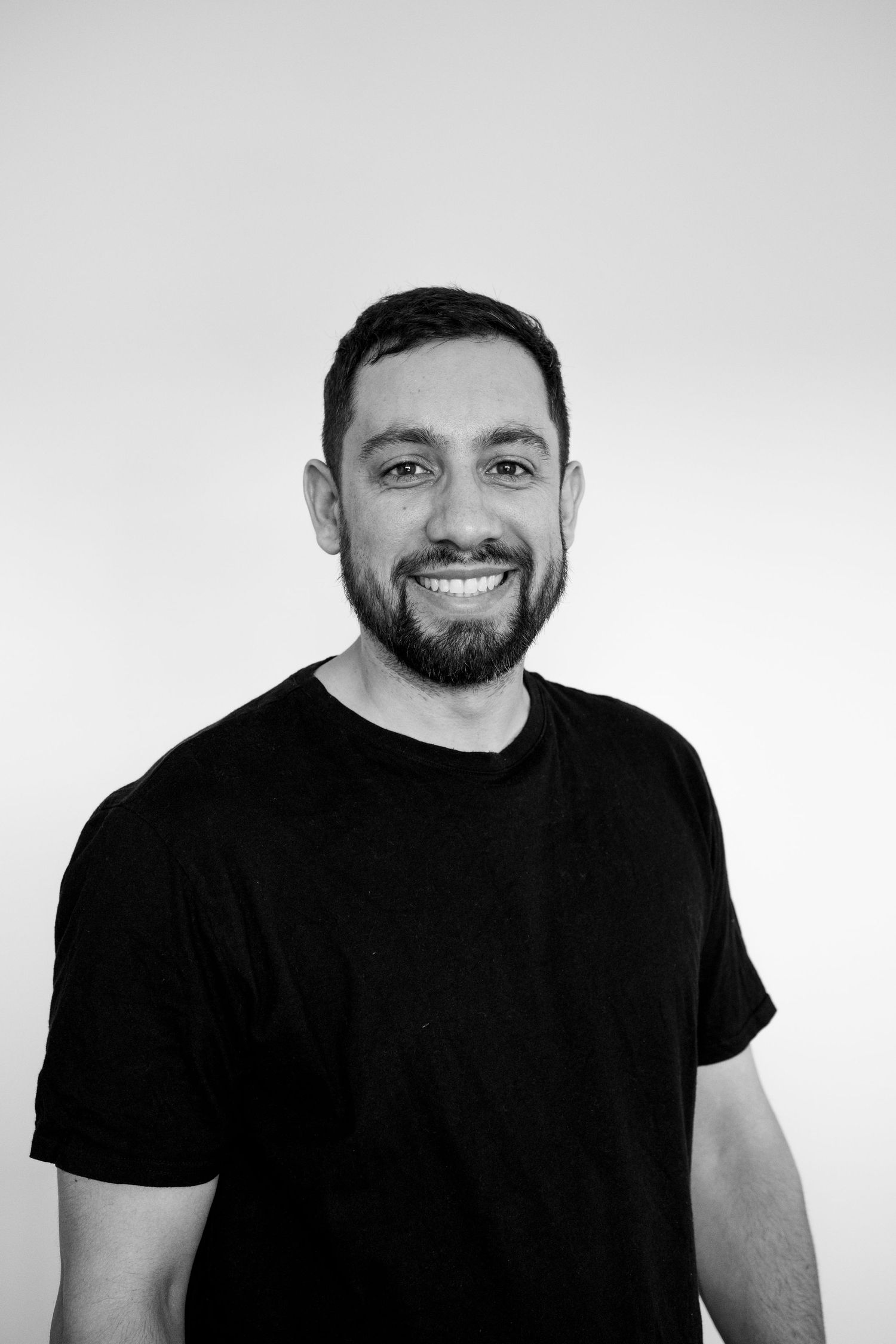 Black and white portrait series showing same person in four similar poses wearing dark t-shirt against light background.