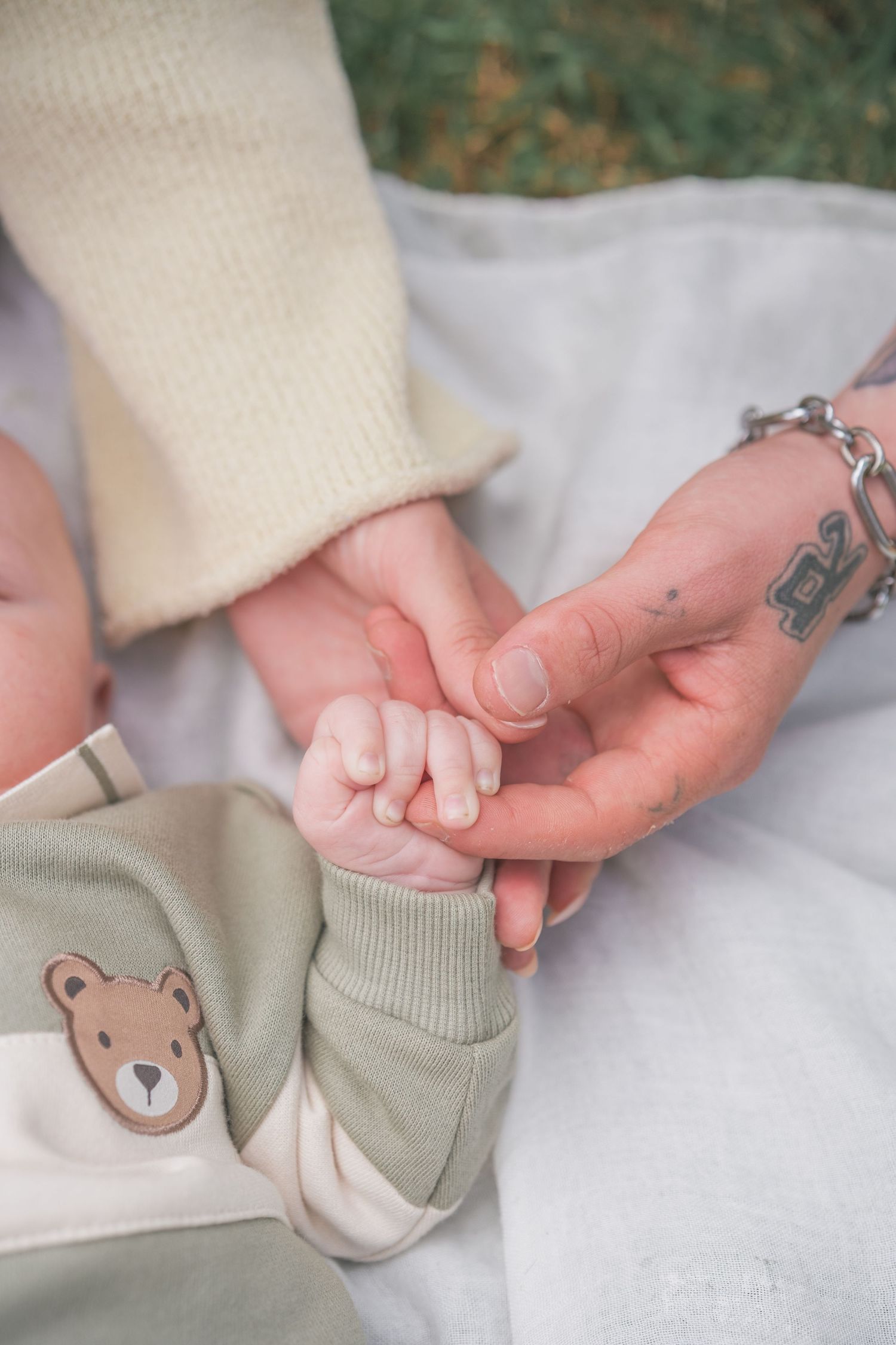 A sequence of photos showing tiny baby feet being gently held while wearing soft teddy bear socks.