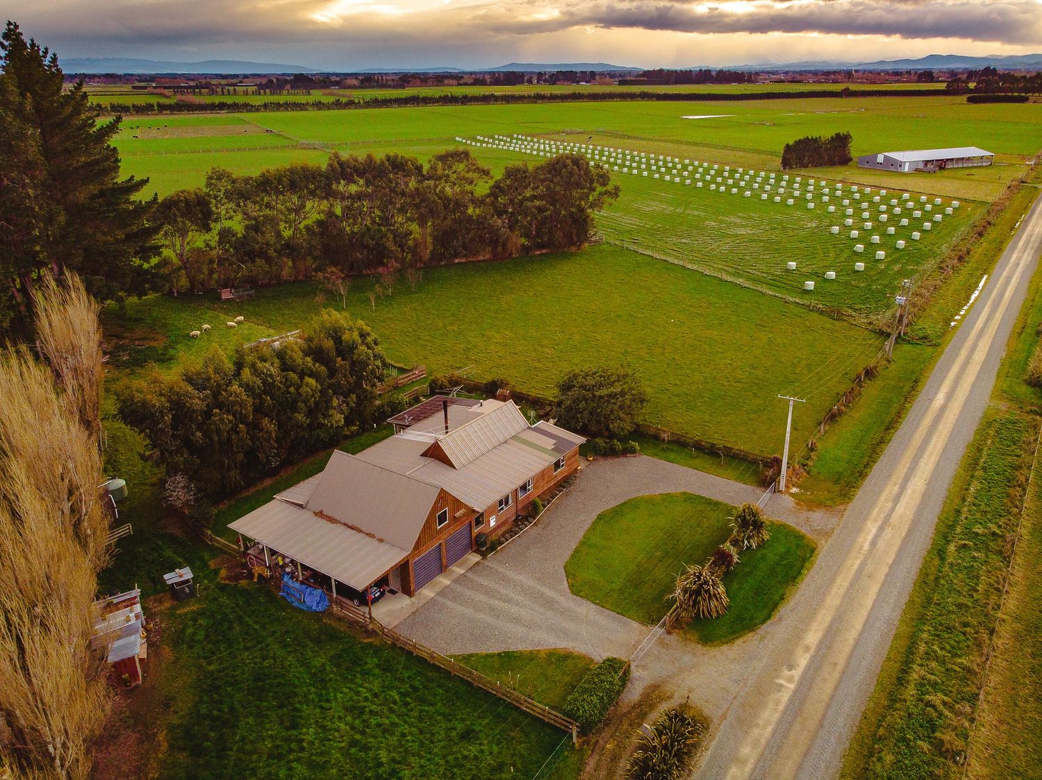 Aerial view of a country church property with manicured grounds and memorial markers at sunset.