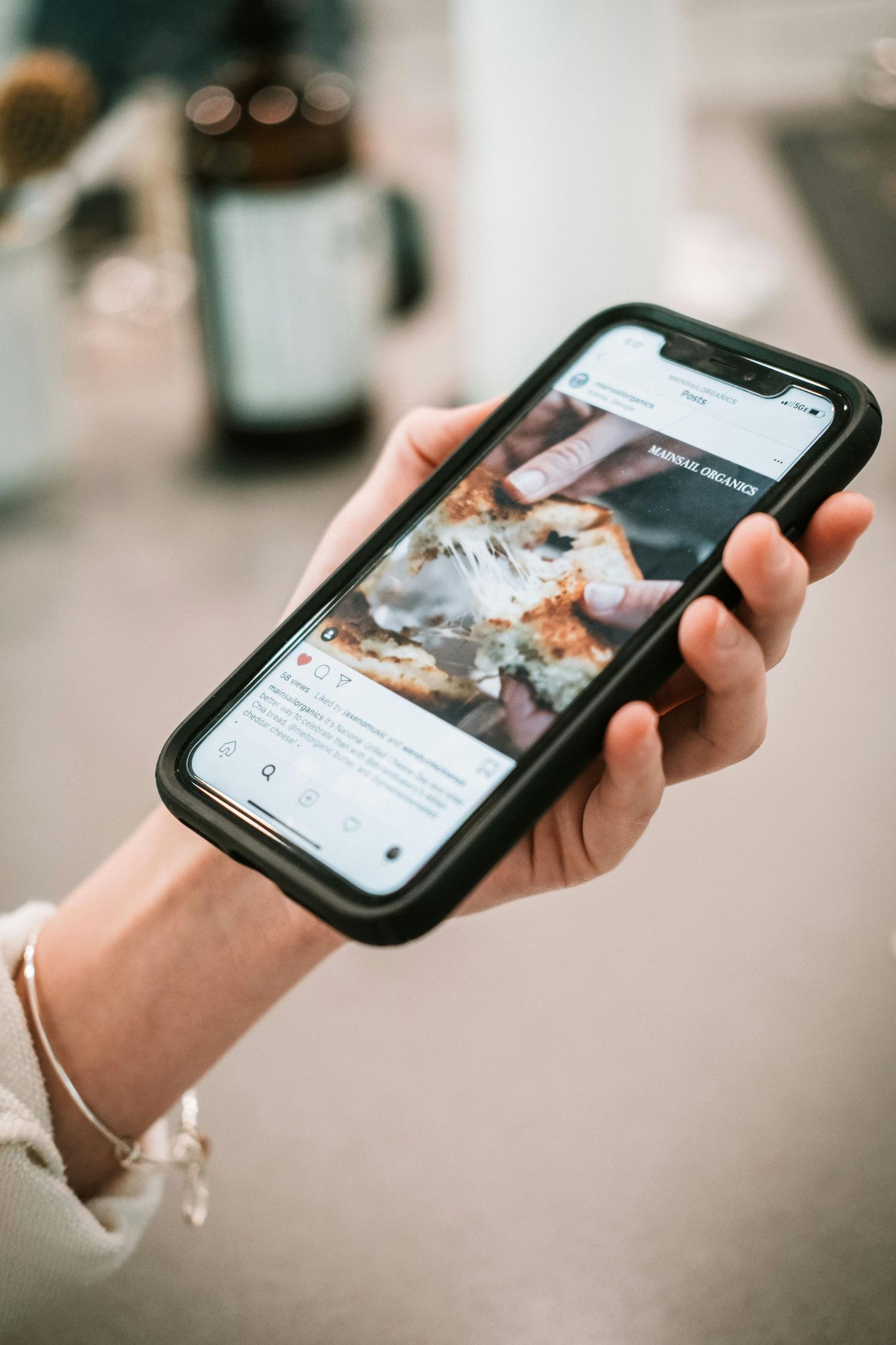 Person holding a smartphone displaying an Instagram food post with a black phone case.