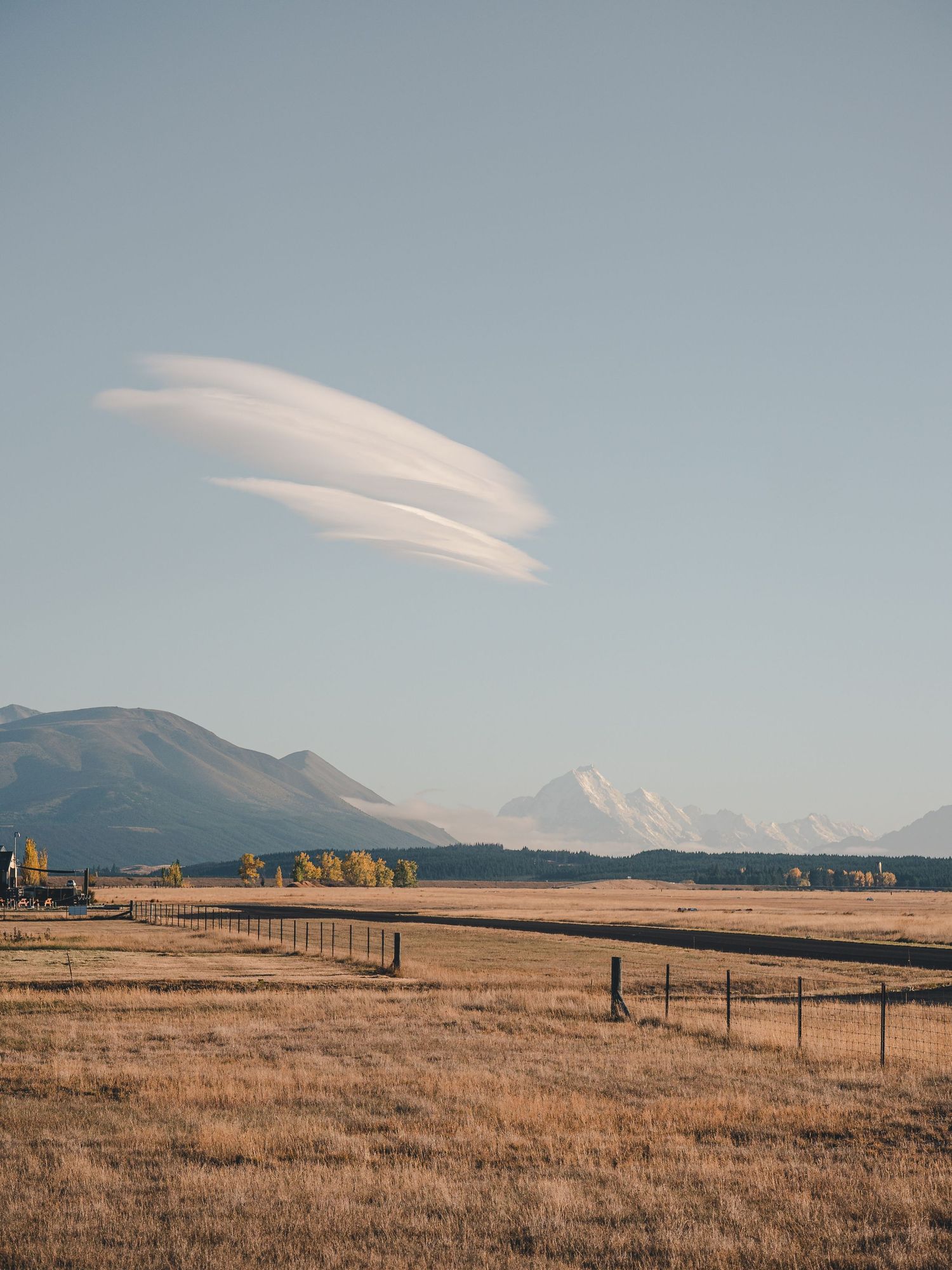 Panoramic sequence of a vast golden prairie field with distant mountains and wispy clouds in the blue sky above.