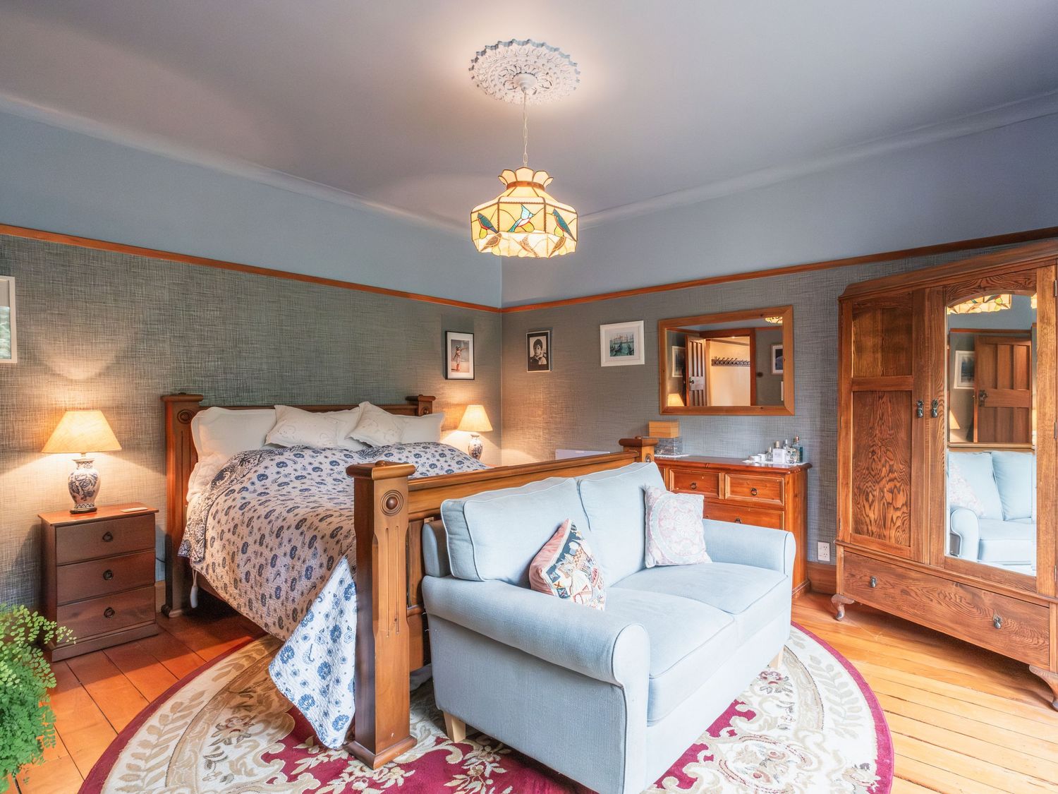 Cozy bedroom interior with wooden walls, white bedding, and warm lighting fixtures creates a rustic mountain lodge atmosphere.