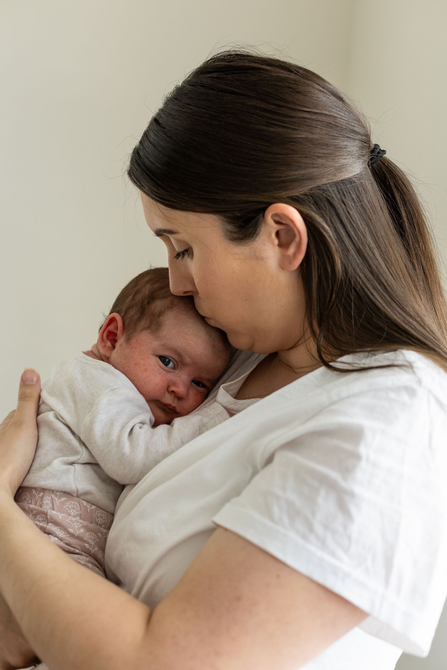 Mother tenderly comforts and cuddles with child in series of intimate close-up shots showing gentle affection.
